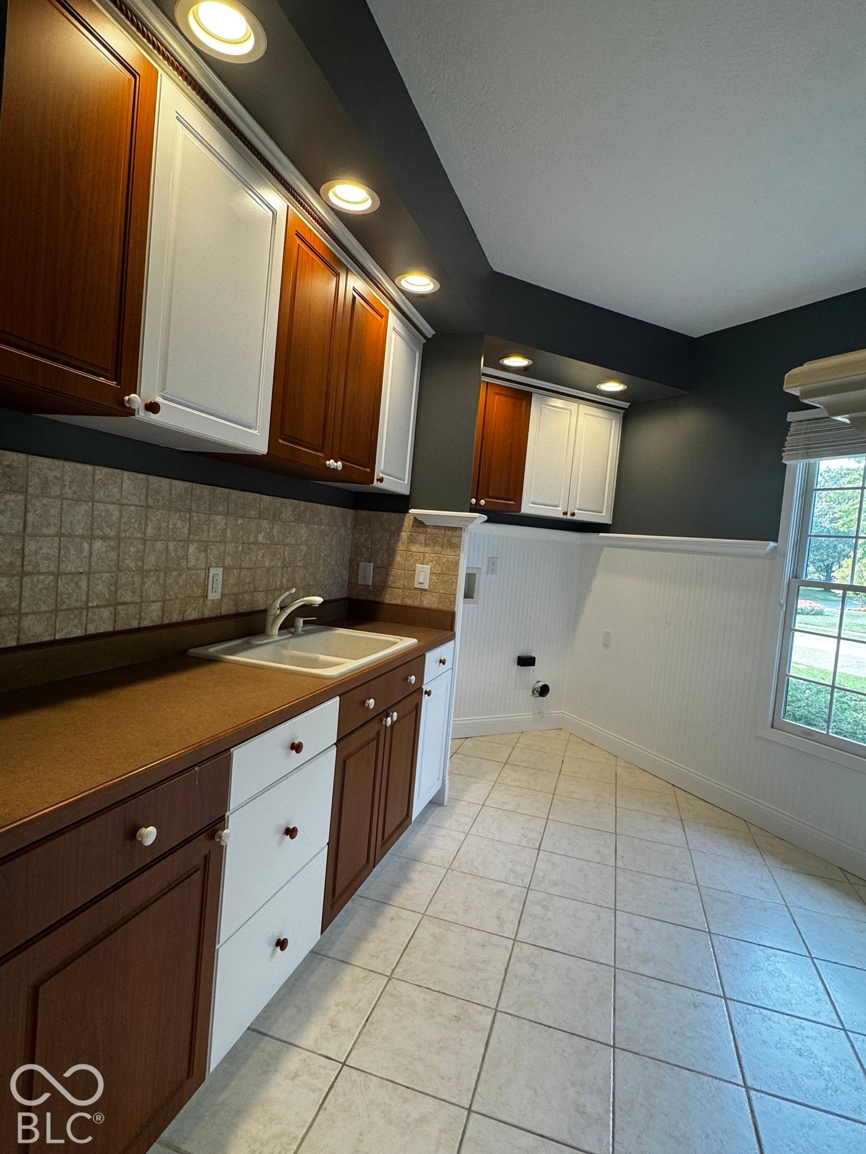 Recessed lighting illuminates two-tone cabinetry with contrasting hardware