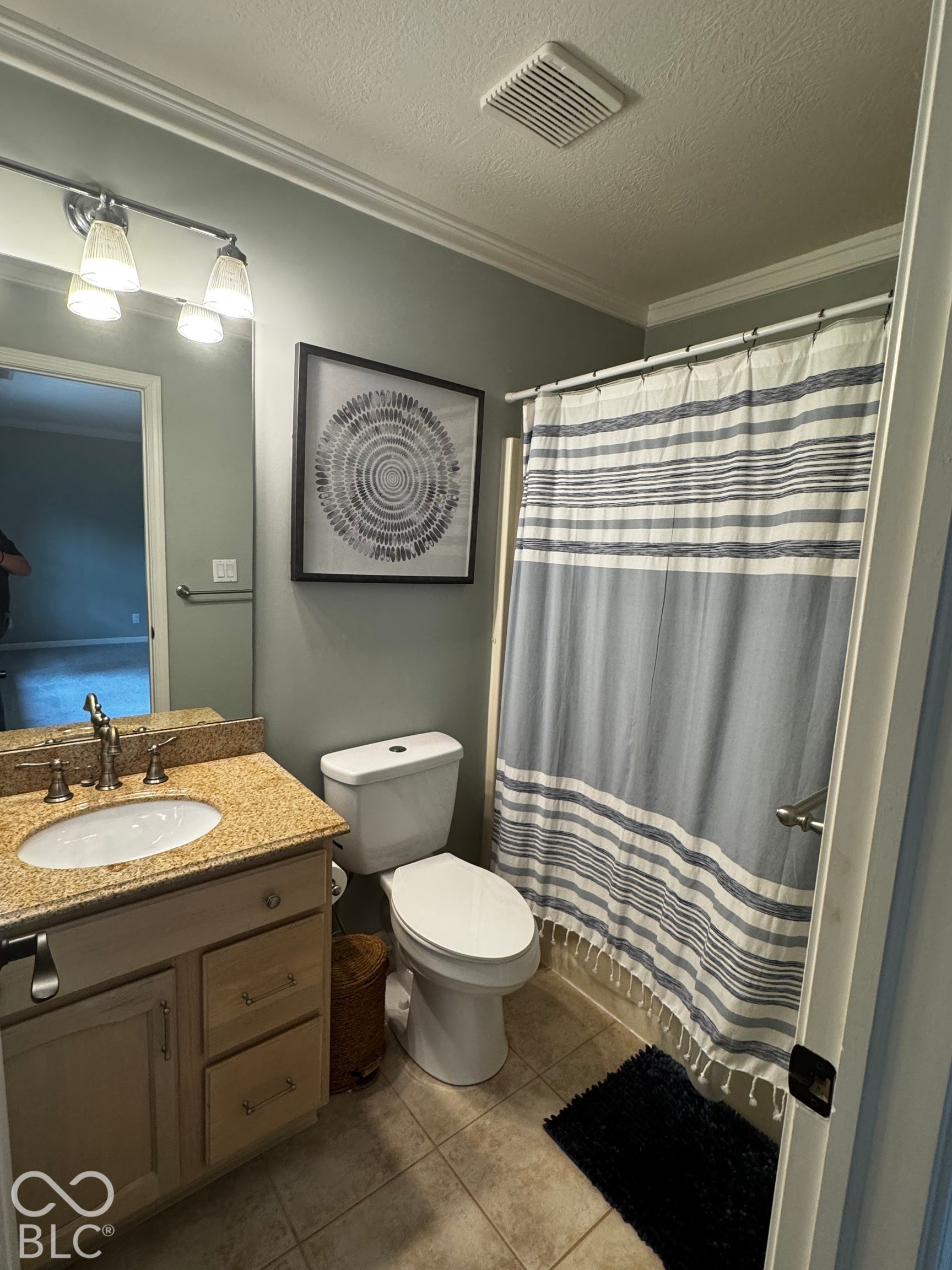 Vanity with granite countertop, undermount sink, and wood-finish cabinetry