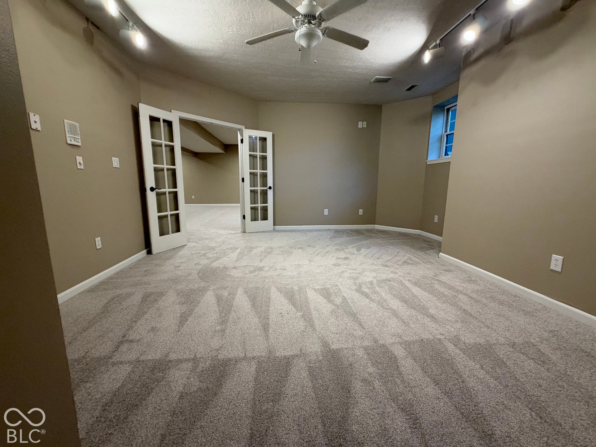 Recessed window, track lighting, ceiling fan, carpeted flooring, and French doors