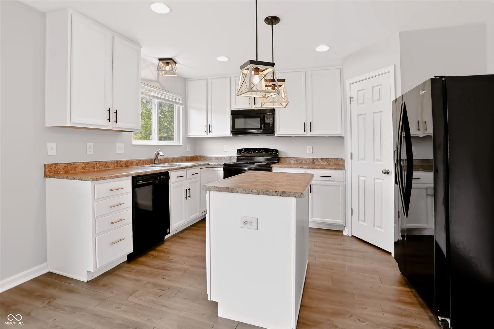 2536 Autumn Road, Indianapolis, IN 46229 Well-appointed kitchen featuring white cabinetry, wood-finish flooring, a central island, and modern pendant lighting