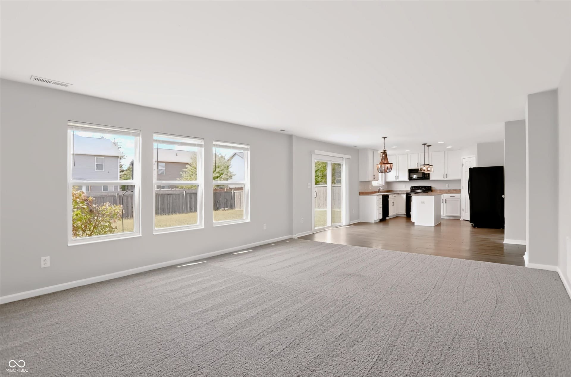 2536 Autumn Road, Indianapolis, IN 46229 Open-concept layout featuring wood-finish flooring in the kitchen, white cabinetry, and a sliding glass door