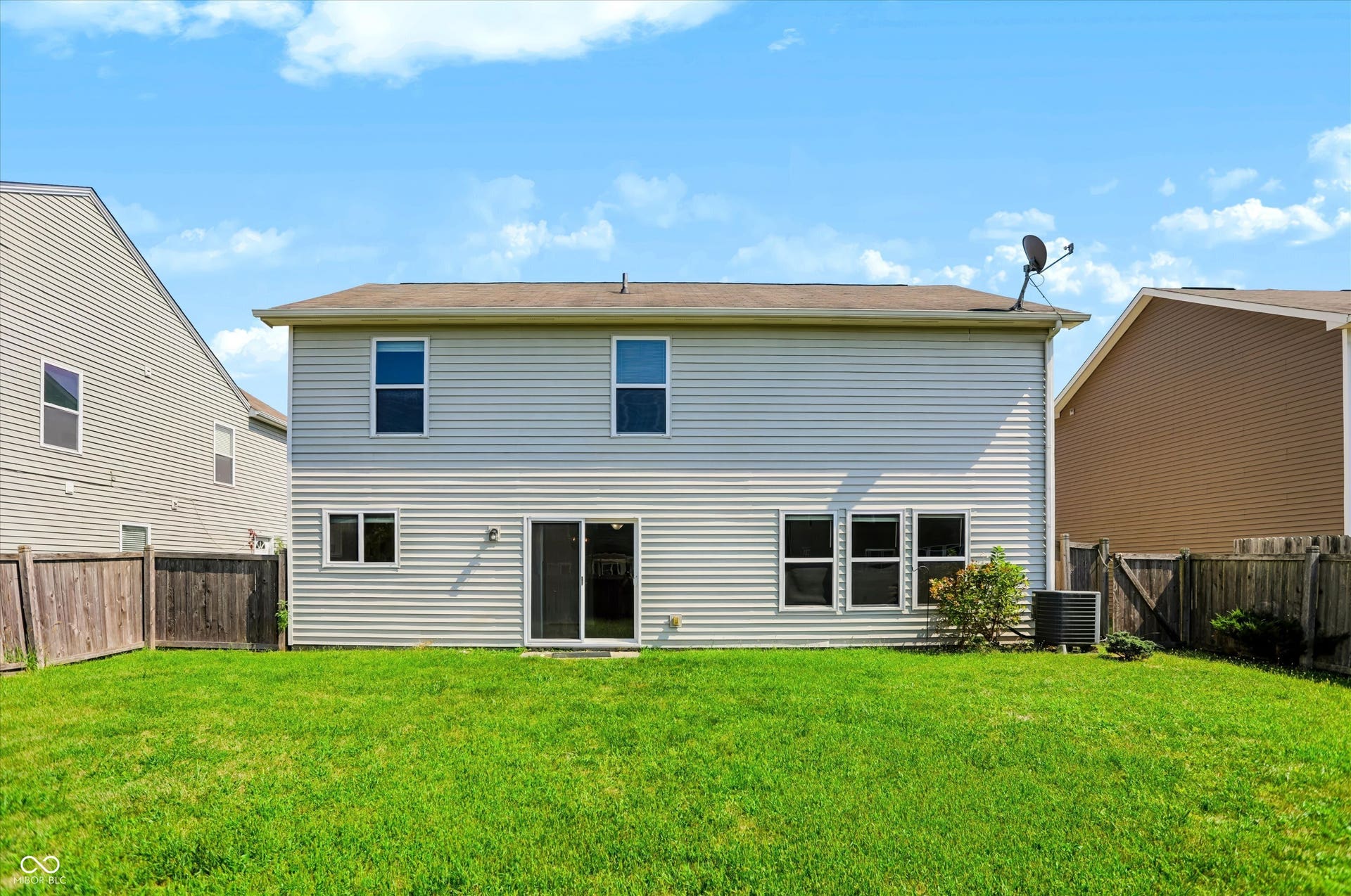 2536 Autumn Road, Indianapolis, IN 46229 Expansive backyard with a manicured lawn, full fencing, and a sliding glass door providing access to the interior