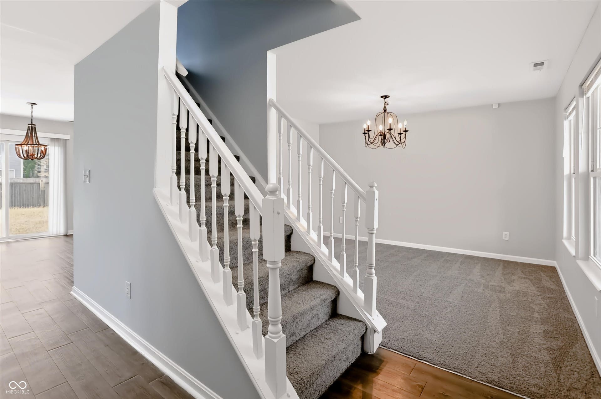 2536 Autumn Road, Indianapolis, IN 46229 Staircase with white balusters and carpeted treads, wood-finish flooring, recessed lighting, and a multi-pane window