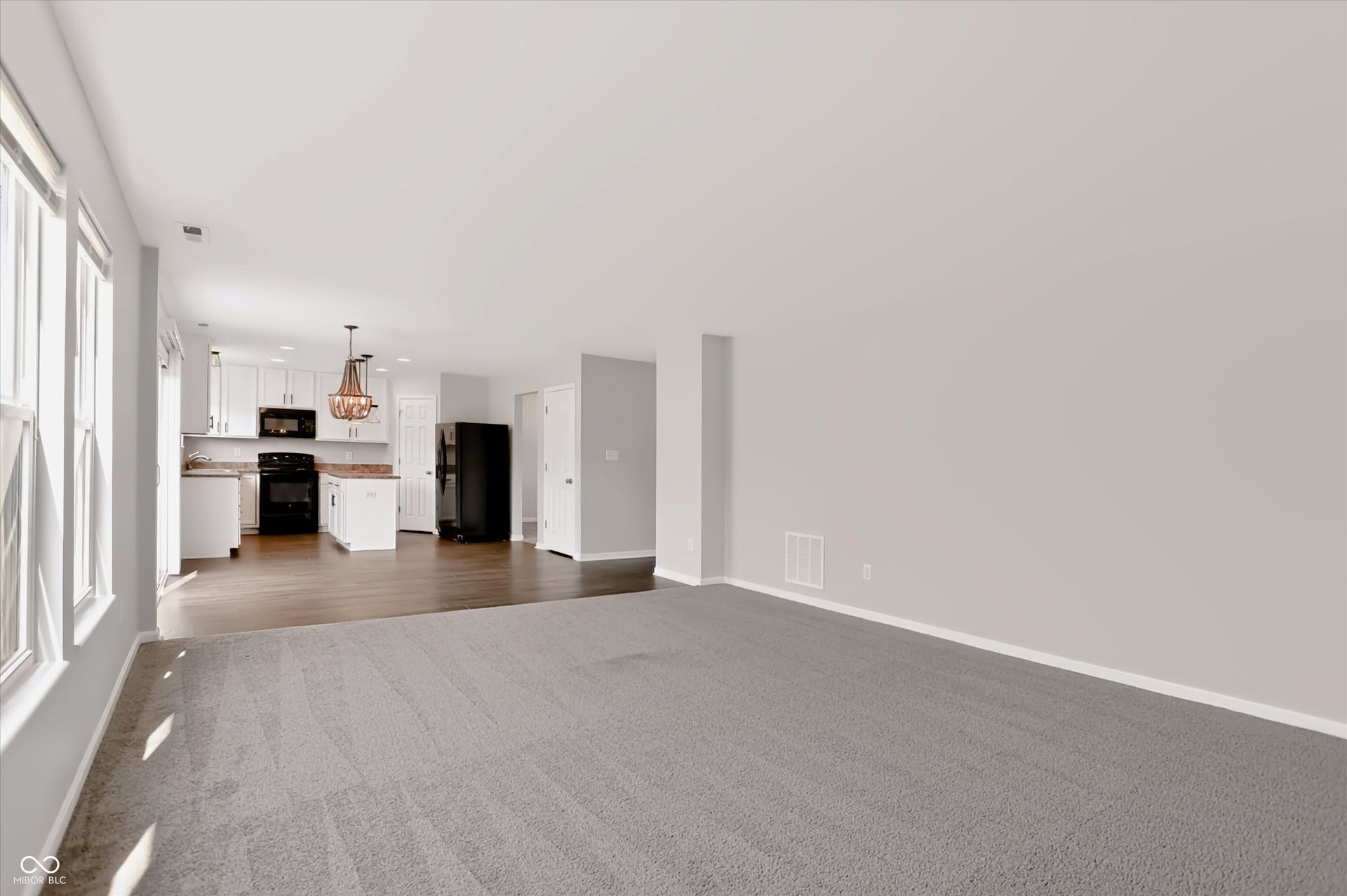 2536 Autumn Road, Indianapolis, IN 46229 Open concept living area with carpeting, kitchen with white cabinetry, black appliances, and a central island