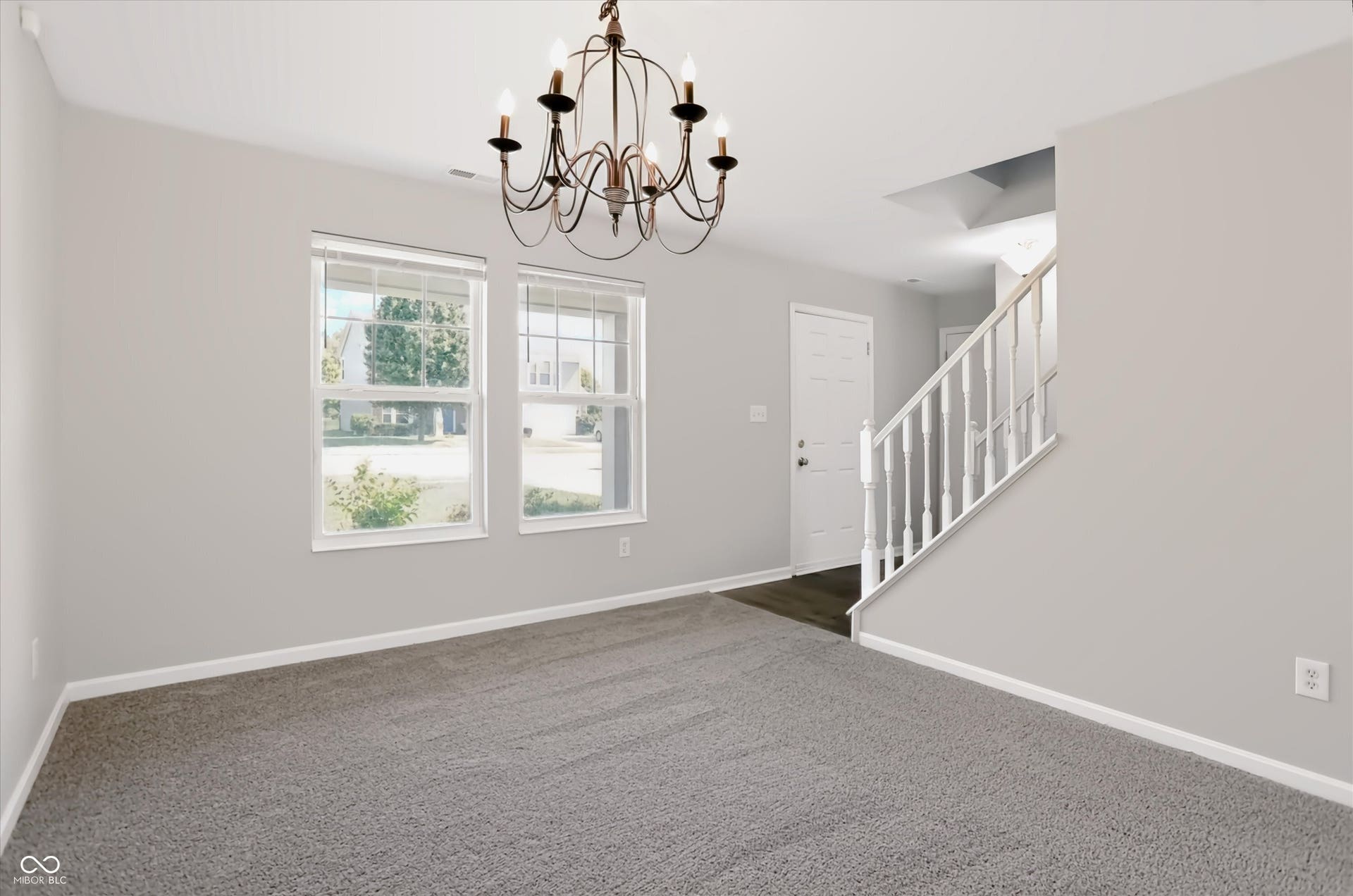 2536 Autumn Road, Indianapolis, IN 46229 Bronze-finish chandelier, neutral-toned walls, two double-hung windows, carpeted flooring, and a white paneled door