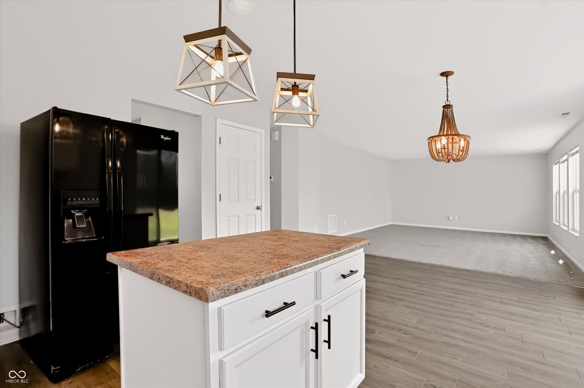 2536 Autumn Road, Indianapolis, IN 46229 Kitchen island with a laminate countertop and white cabinetry, wood-finish flooring, and two pendant lights