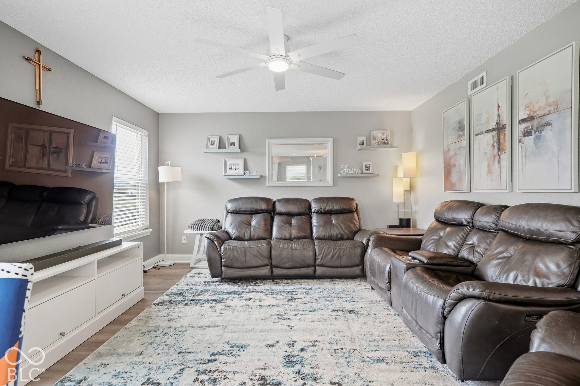 Wood-finish flooring, white ceiling fan, and window with blinds