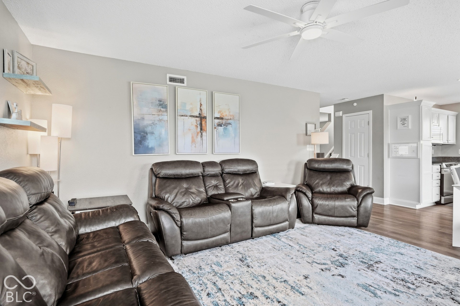 Recessed lighting, ceiling fan, and wood-finish flooring create a bright, functional living space