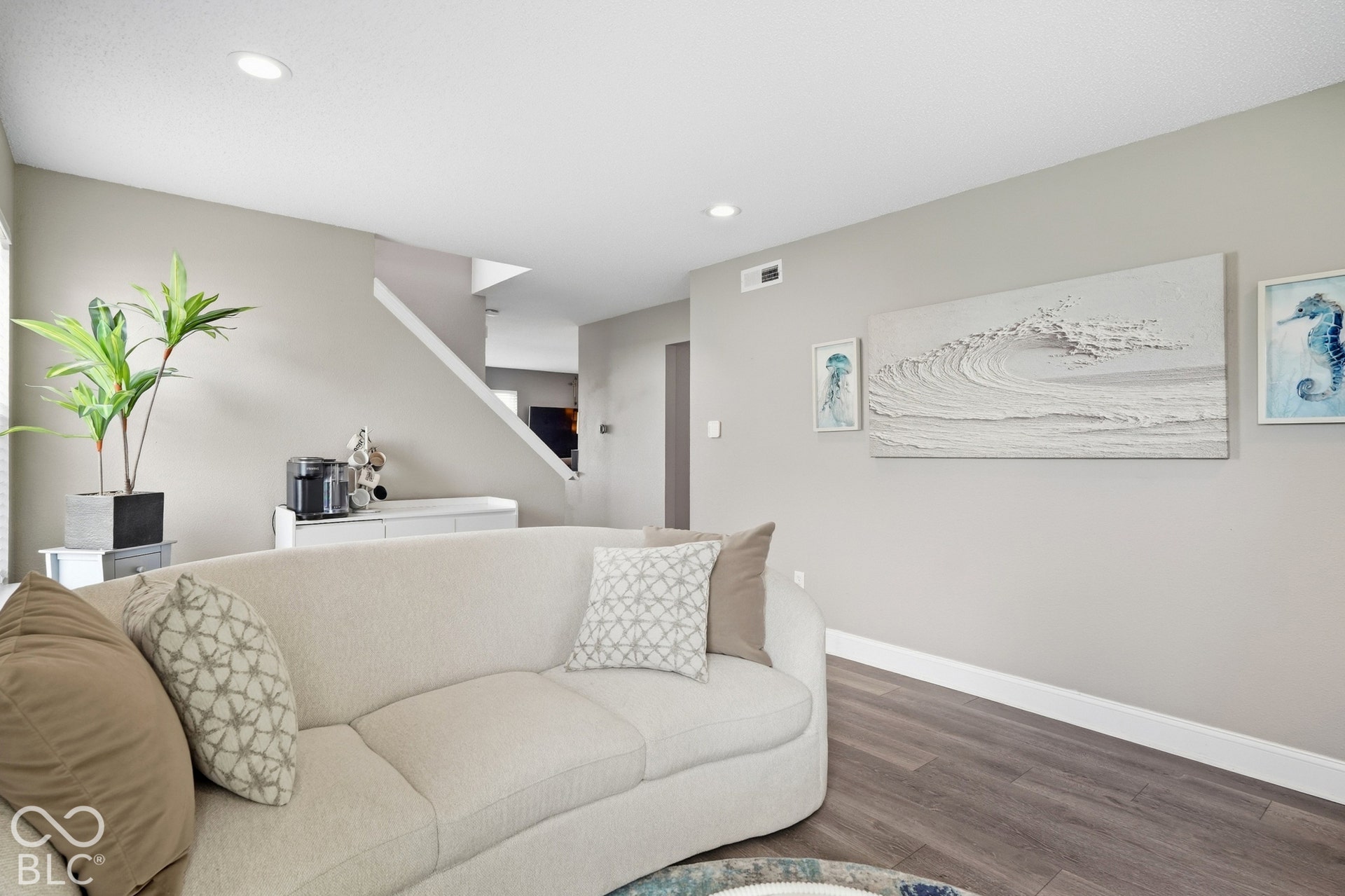 Recessed ceiling lighting, wood-finish flooring, white trim, and a built-in credenza
