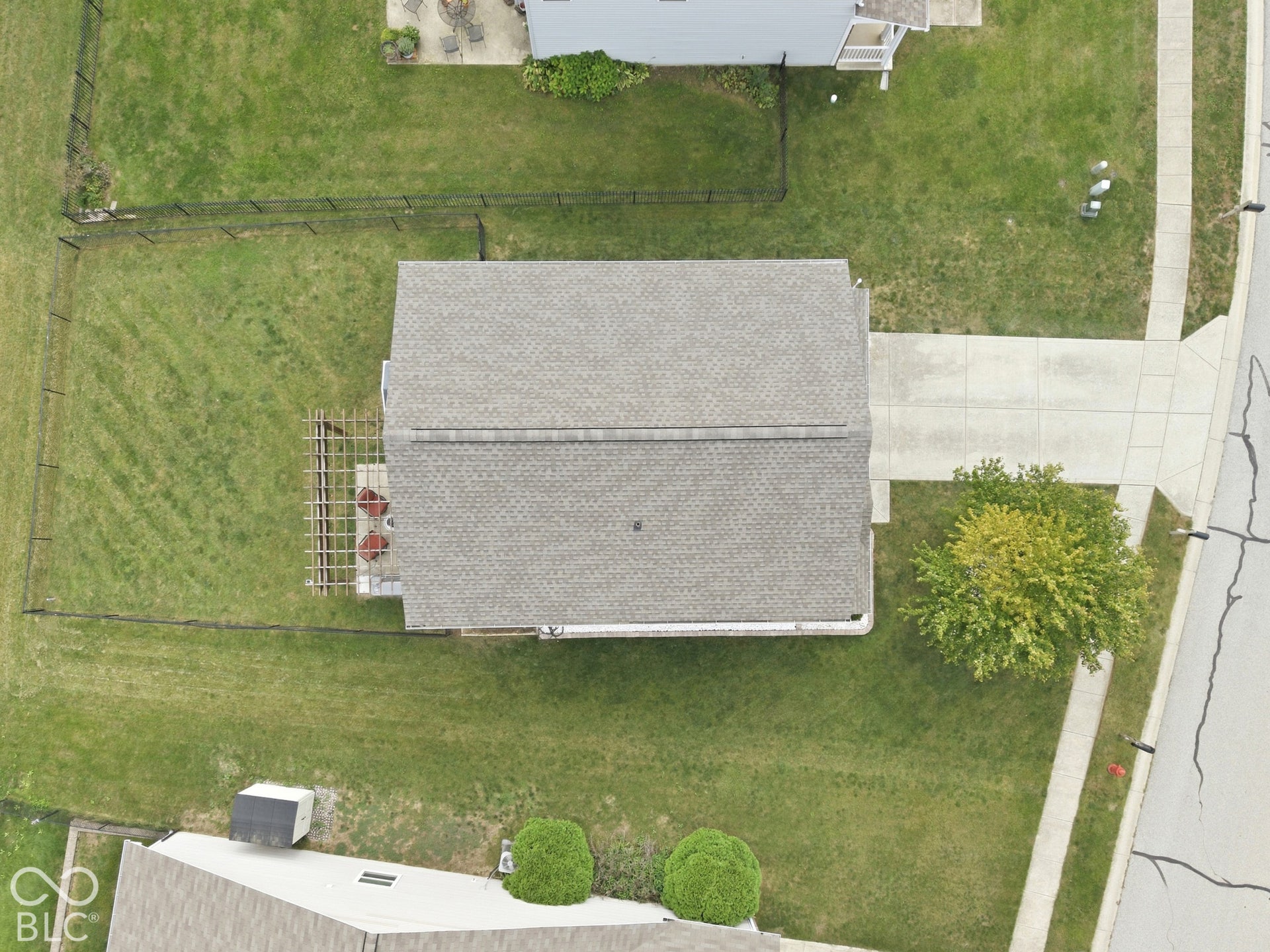 Gable roofline, rear patio with pergola, fenced yard, concrete driveway, and established tree