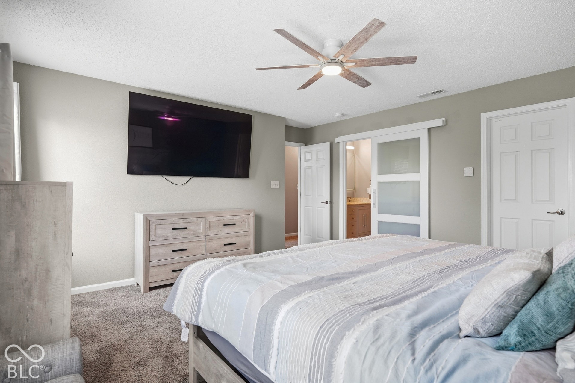 Recessed lighting, ceiling fan, carpet flooring, and a sliding door with frosted glass panels