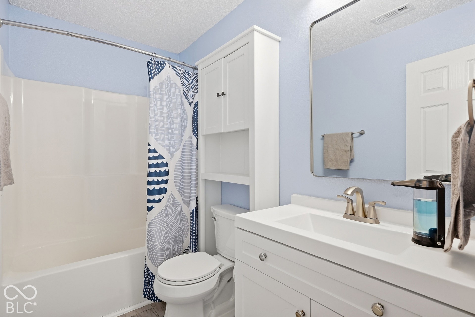 White vanity with an integrated sink and brushed nickel faucet