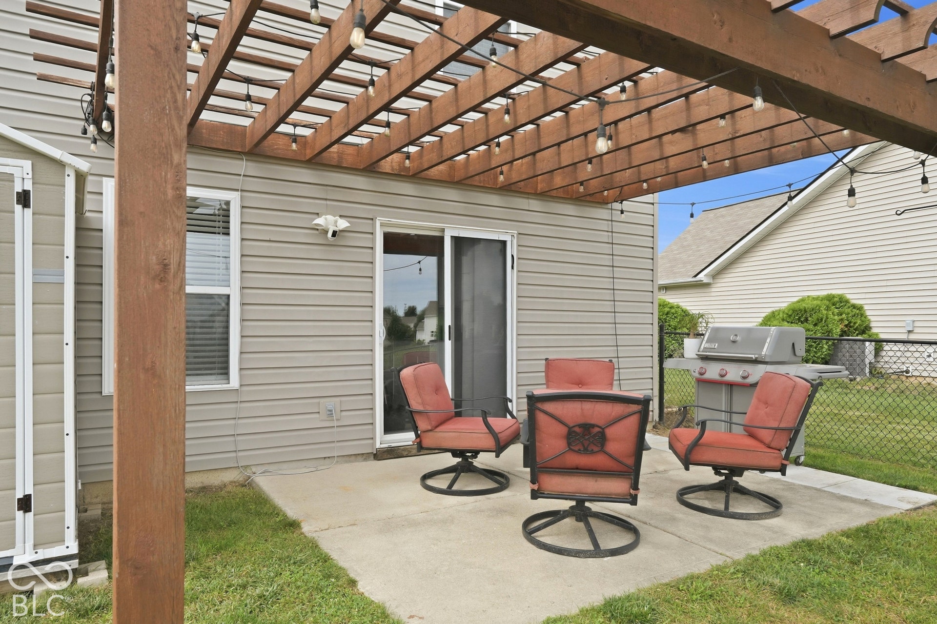 Backyard patio featuring a wood pergola and concrete hardscaping