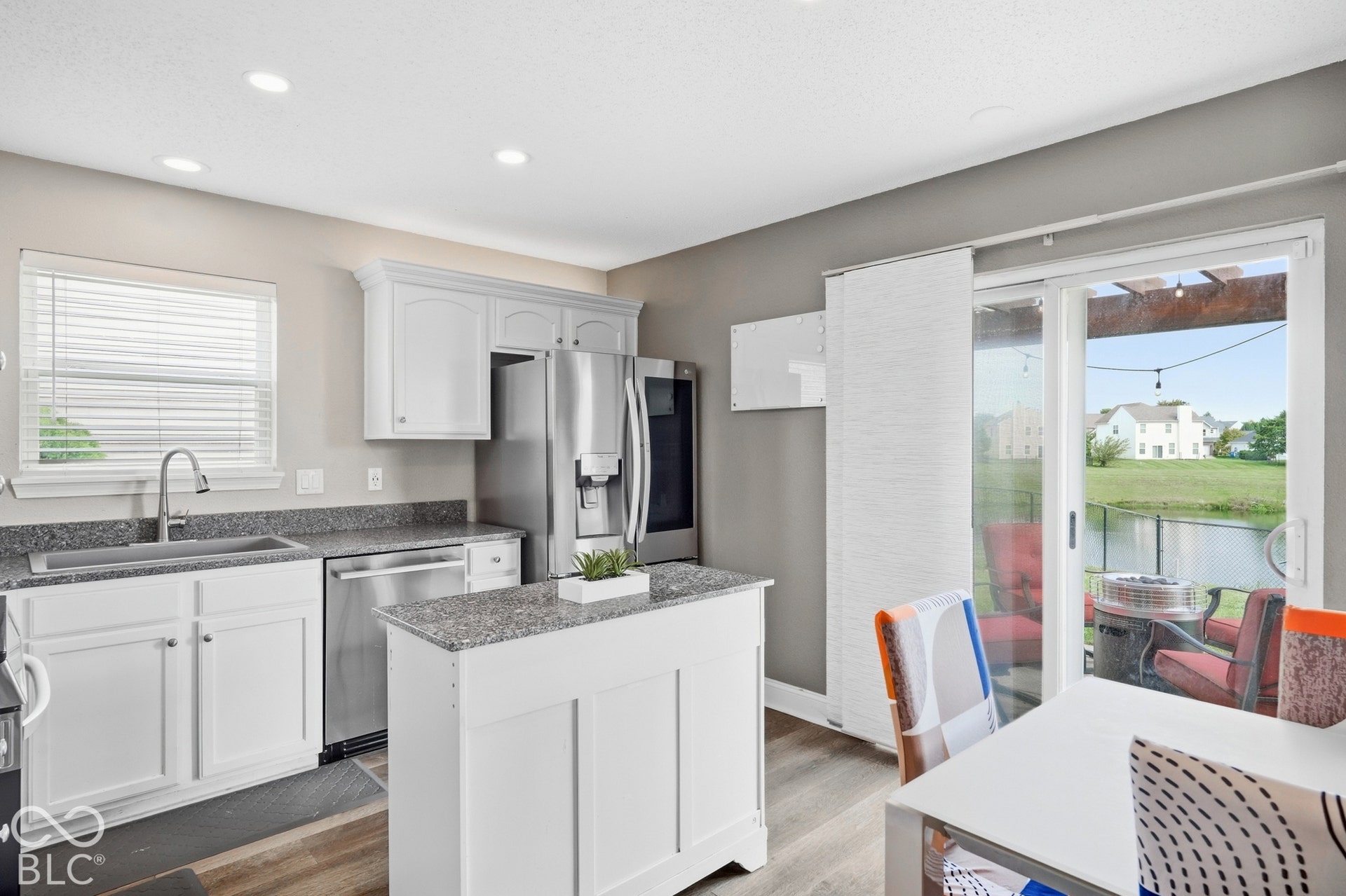Kitchen featuring white cabinetry, stainless steel appliances, quartz countertops, and a center island