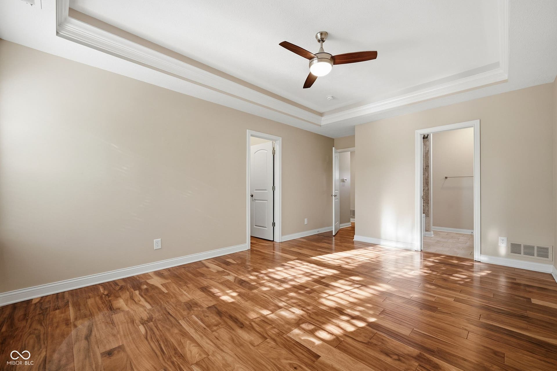 2743 Rylee Court, Greenwood, IN 46143 Acacia hardwood floors, lighted tray ceiling, crown molding, ceiling fan, and neutral wall tones