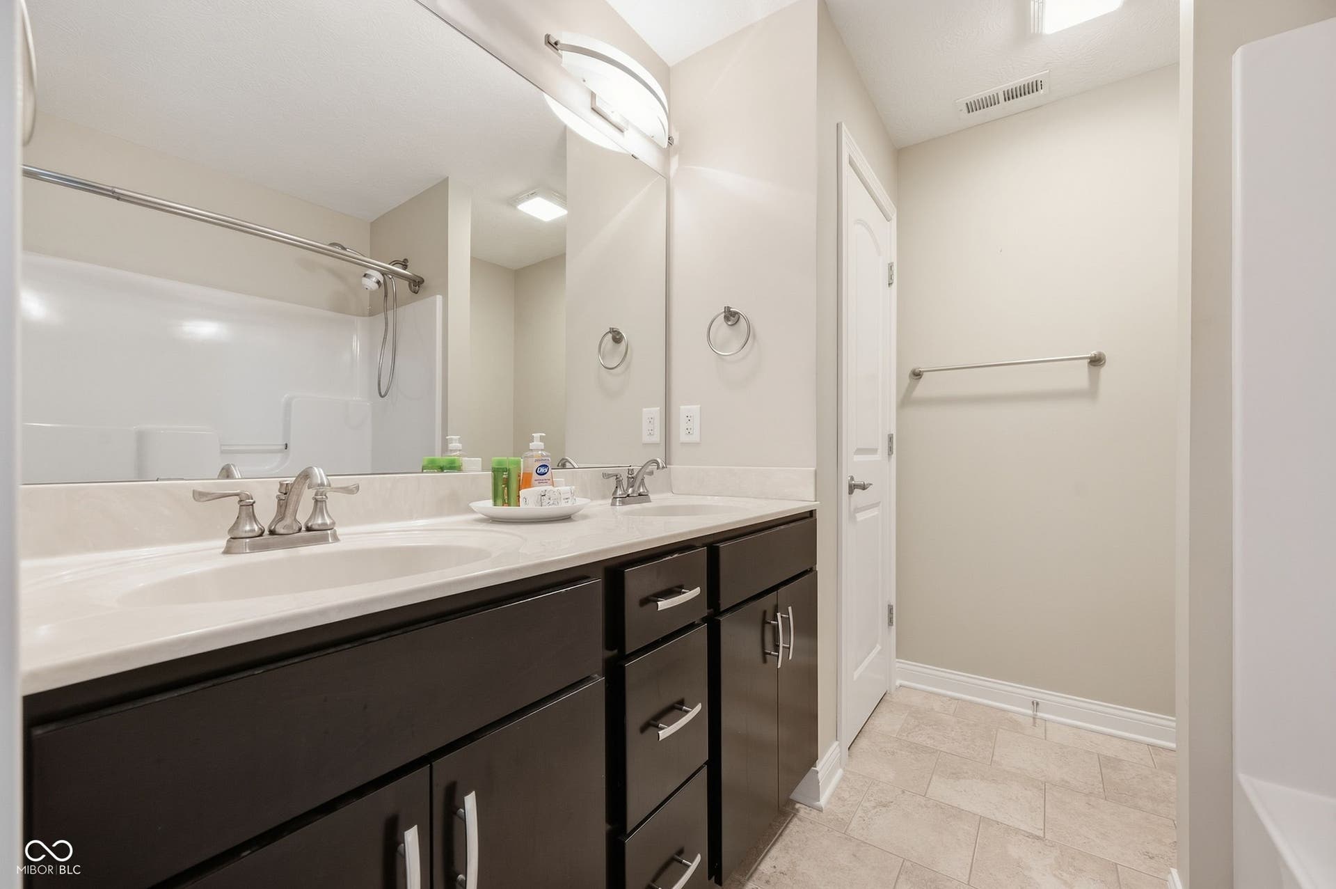 2743 Rylee Court, Greenwood, IN 46143 Dual vanity with integrated sinks, dark wood-finish cabinetry, and brushed nickel fixtures