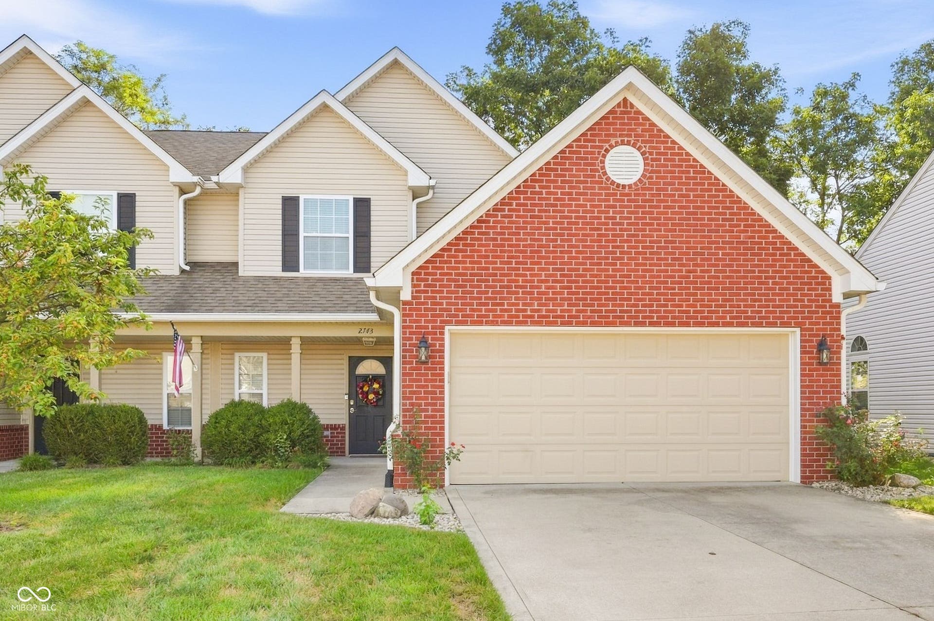 2743 Rylee Court, Greenwood, IN 46143 Traditional-style exterior with brick and siding facade, covered front entry, attached two-car garage, and large concrete driveway