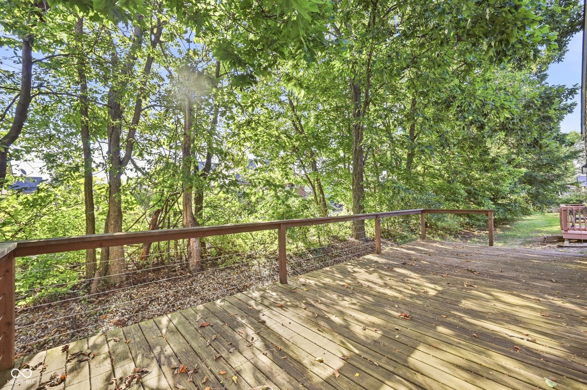 2743 Rylee Court, Greenwood, IN 46143 Expansive wood-plank deck with a cable railing system, surrounded by mature trees