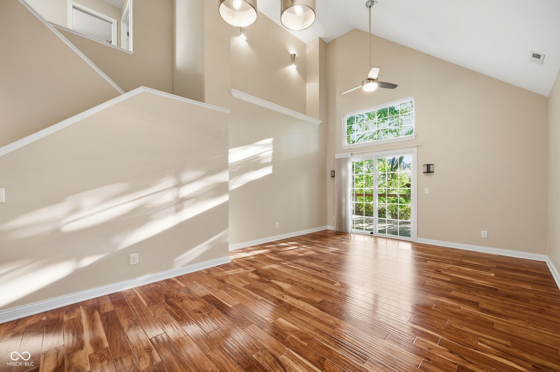 2743 Rylee Court, Greenwood, IN 46143 Vaulted ceiling with a ceiling fan, acacia hardwood floors, and sliding glass doors with transom windows