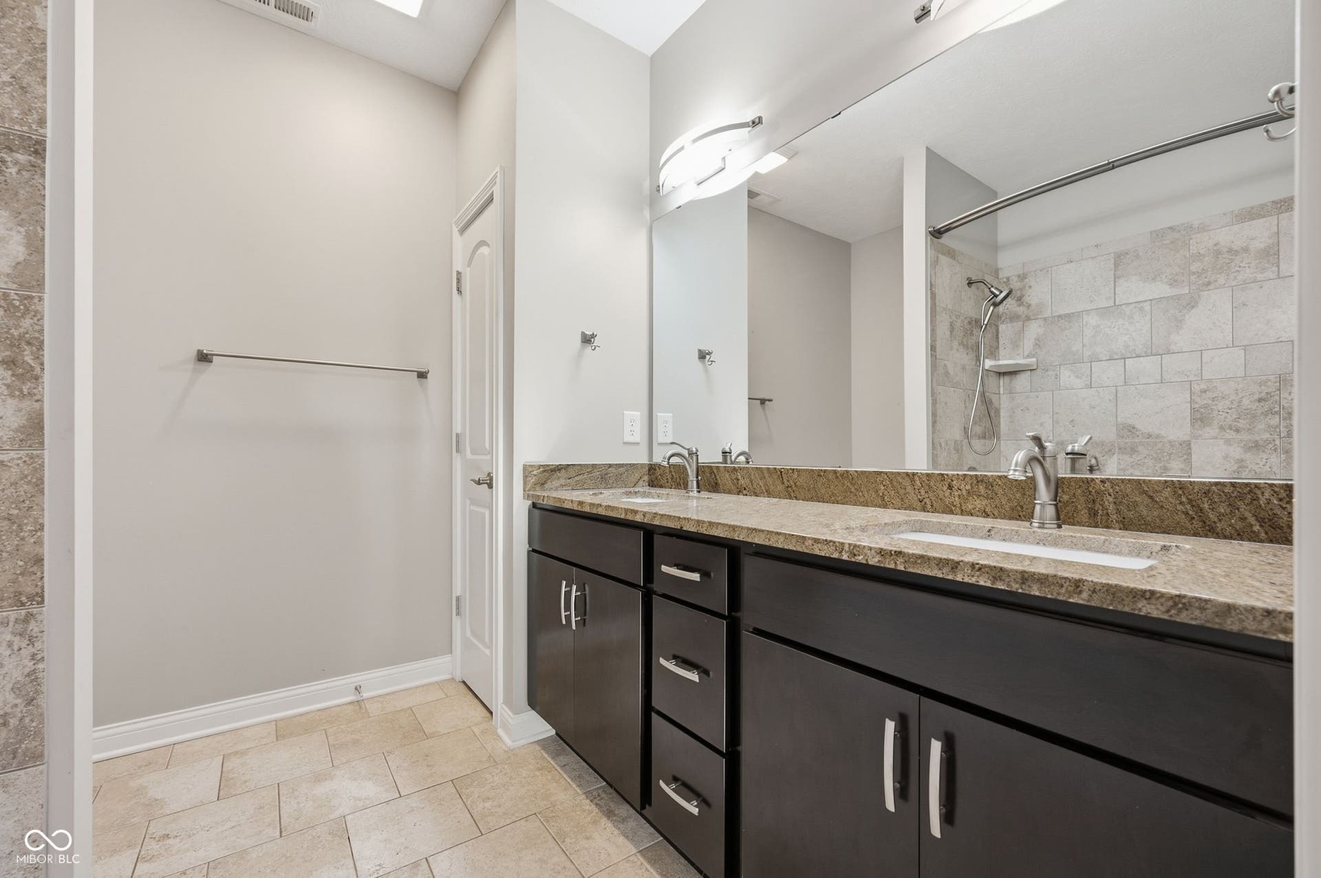 2743 Rylee Court, Greenwood, IN 46143 Dual vanity with integrated sinks, a stone countertop, dark wood-finish cabinetry, and brushed nickel hardware