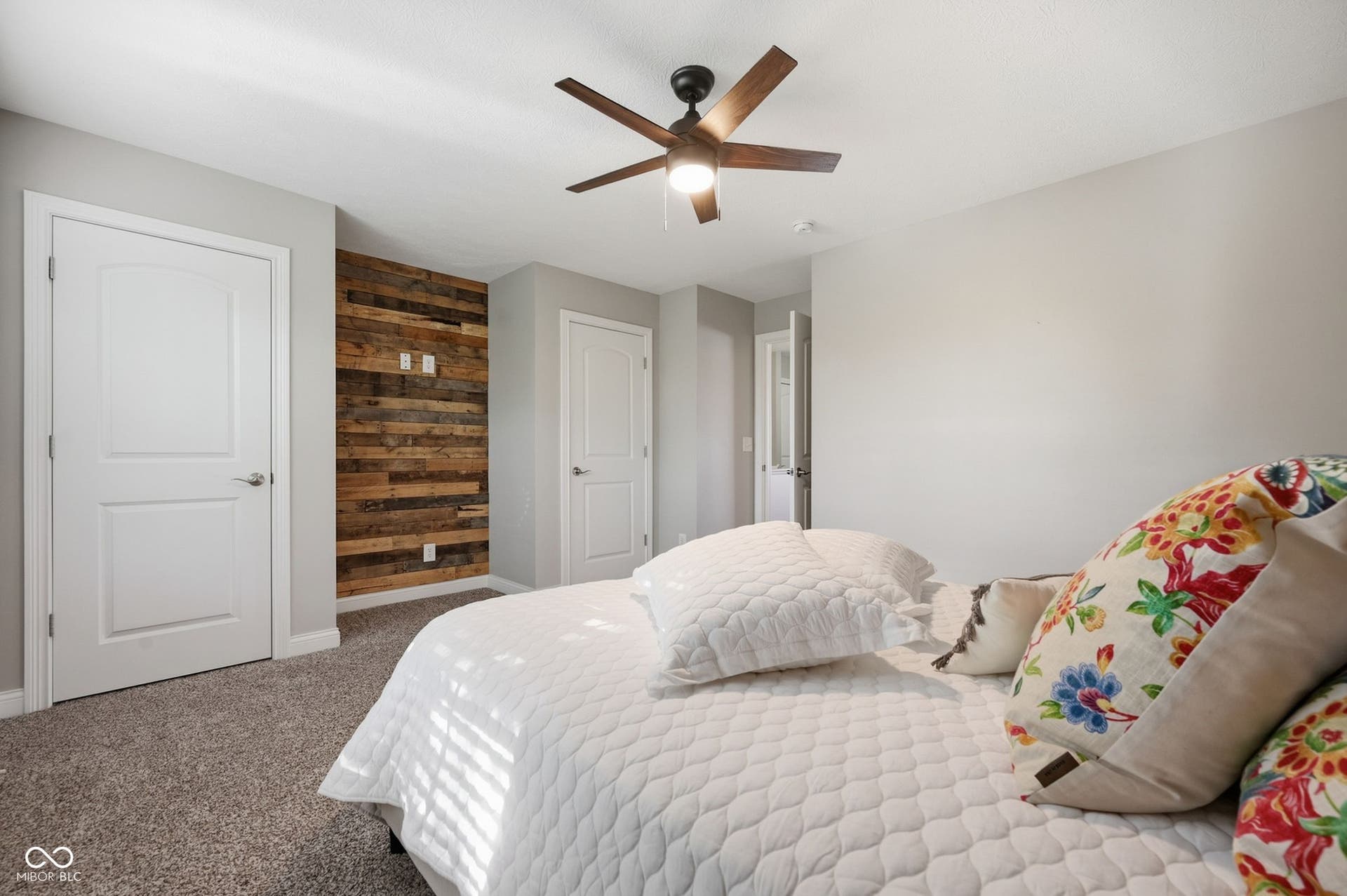 2743 Rylee Court, Greenwood, IN 46143 Accent wall featuring wood-finish paneling, contemporary ceiling fan with integrated lighting, and light gray wall paint