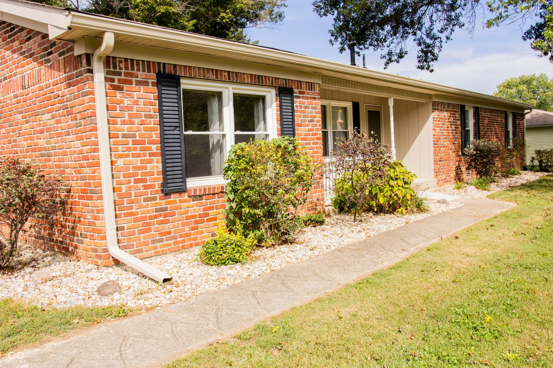 Brick exterior with white gutters and dark shutters