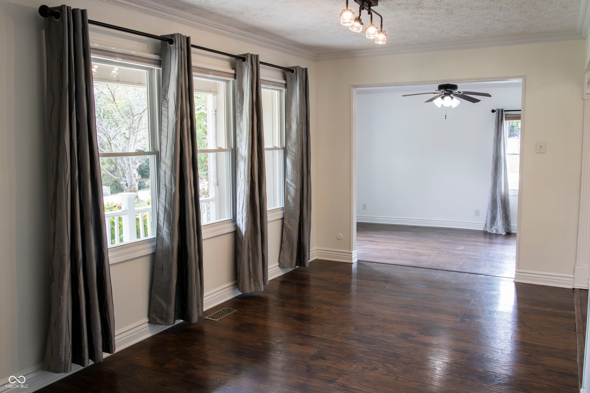 Hardwood flooring throughout, multiple windows, crown molding, and a contemporary ceiling fixture
