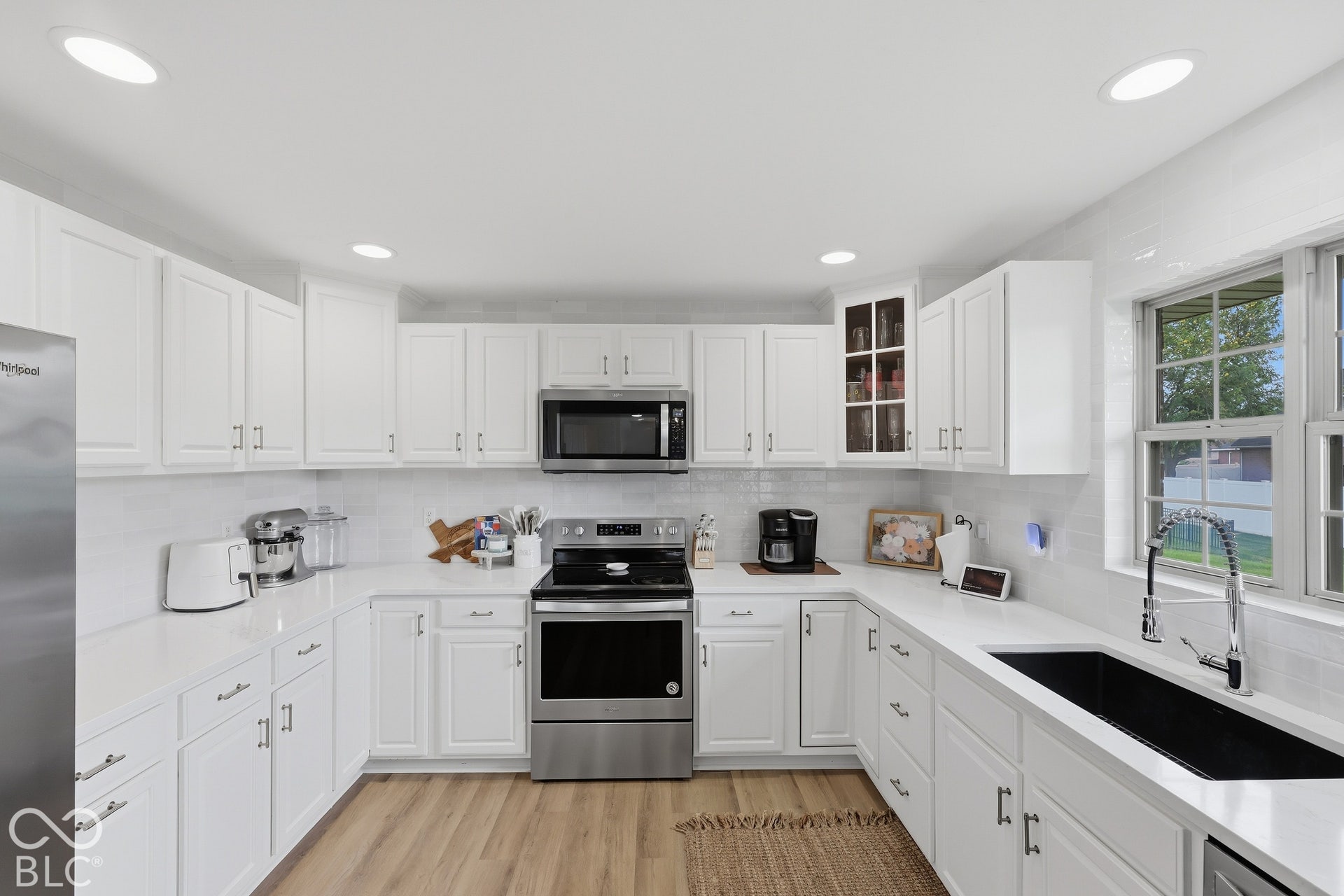 Updated 10x12 kitchen offers abundant cabinetry, pantry, deep stainless steel sink, new hardware, new backsplash that extends from the countertops to the ceiling. A large window brings in natural light, and new hardwood floors.