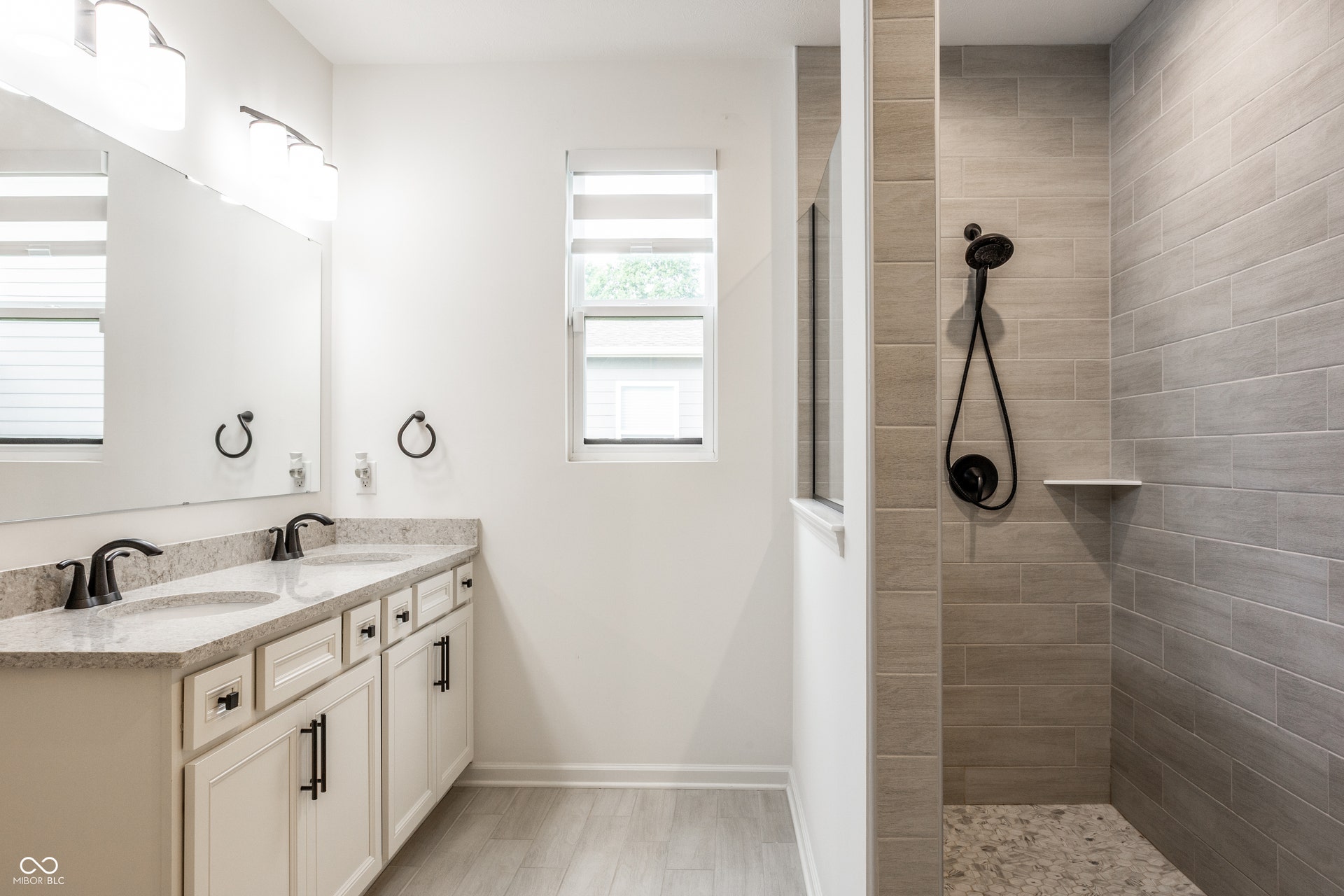 Master bath with double sinks and quartz counter top, and tiled walk in shower