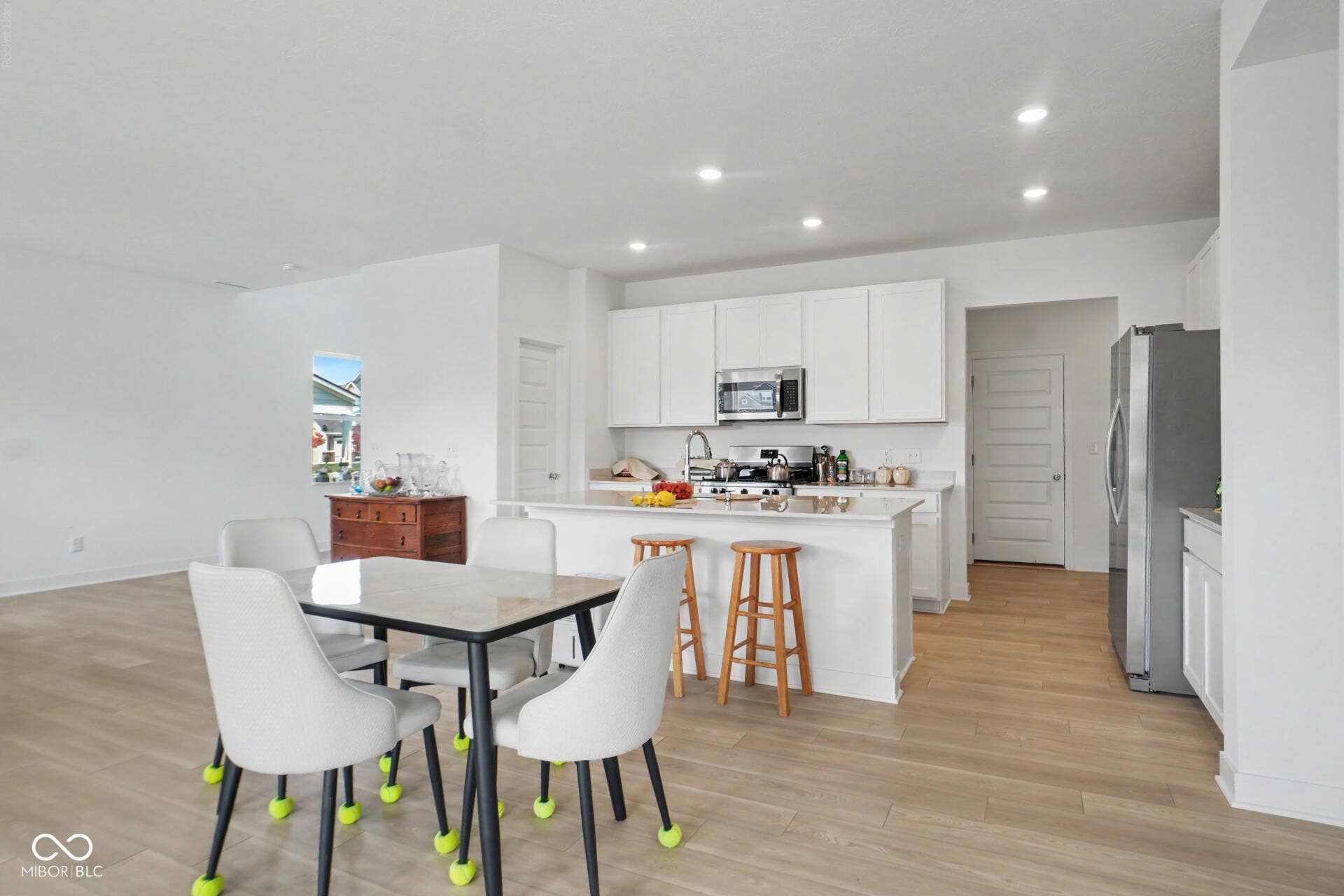 4357 Red Pine Drive, Bargersville, IN 46106 Open-concept kitchen and dining area featuring white cabinetry, stainless steel appliances, wood-finish flooring, recessed ceiling lighting, and a central island with seating