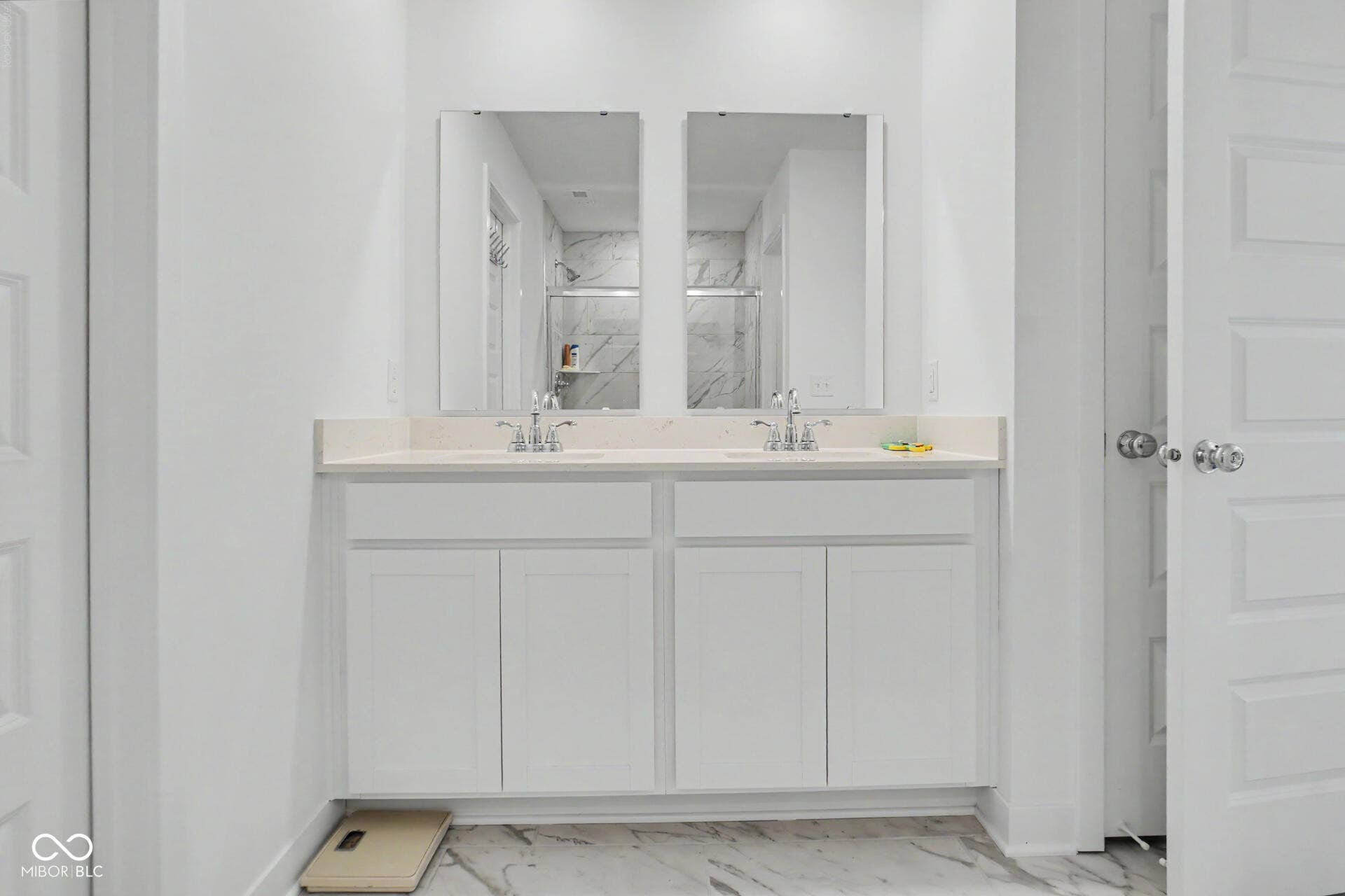 4357 Red Pine Drive, Bargersville, IN 46106 Dual vanity with integrated sinks, light-toned countertop, white cabinetry, and wall-mounted mirrors