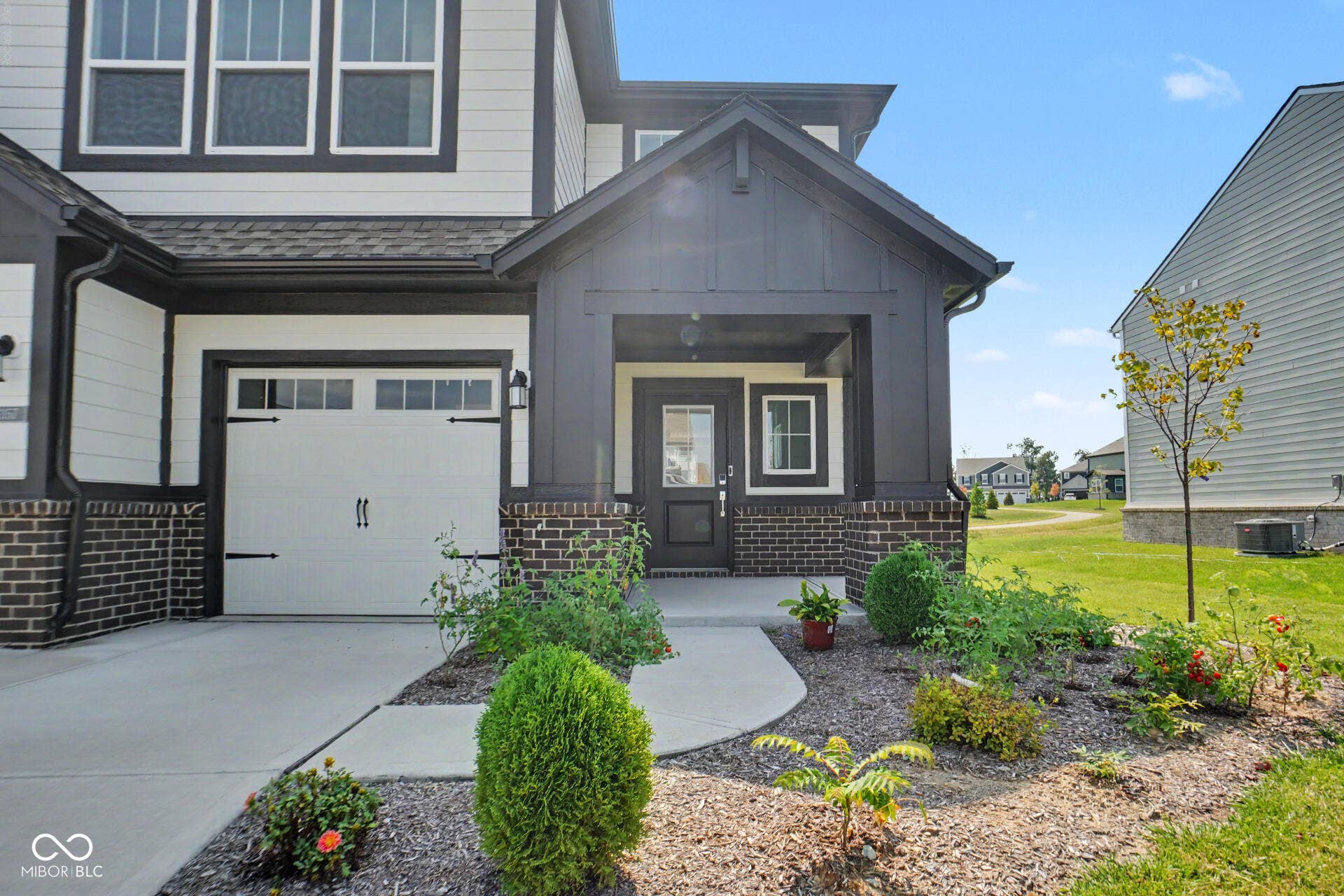 4357 Red Pine Drive, Bargersville, IN 46106 Contemporary exterior featuring a white garage door, dark trim, and a covered entry