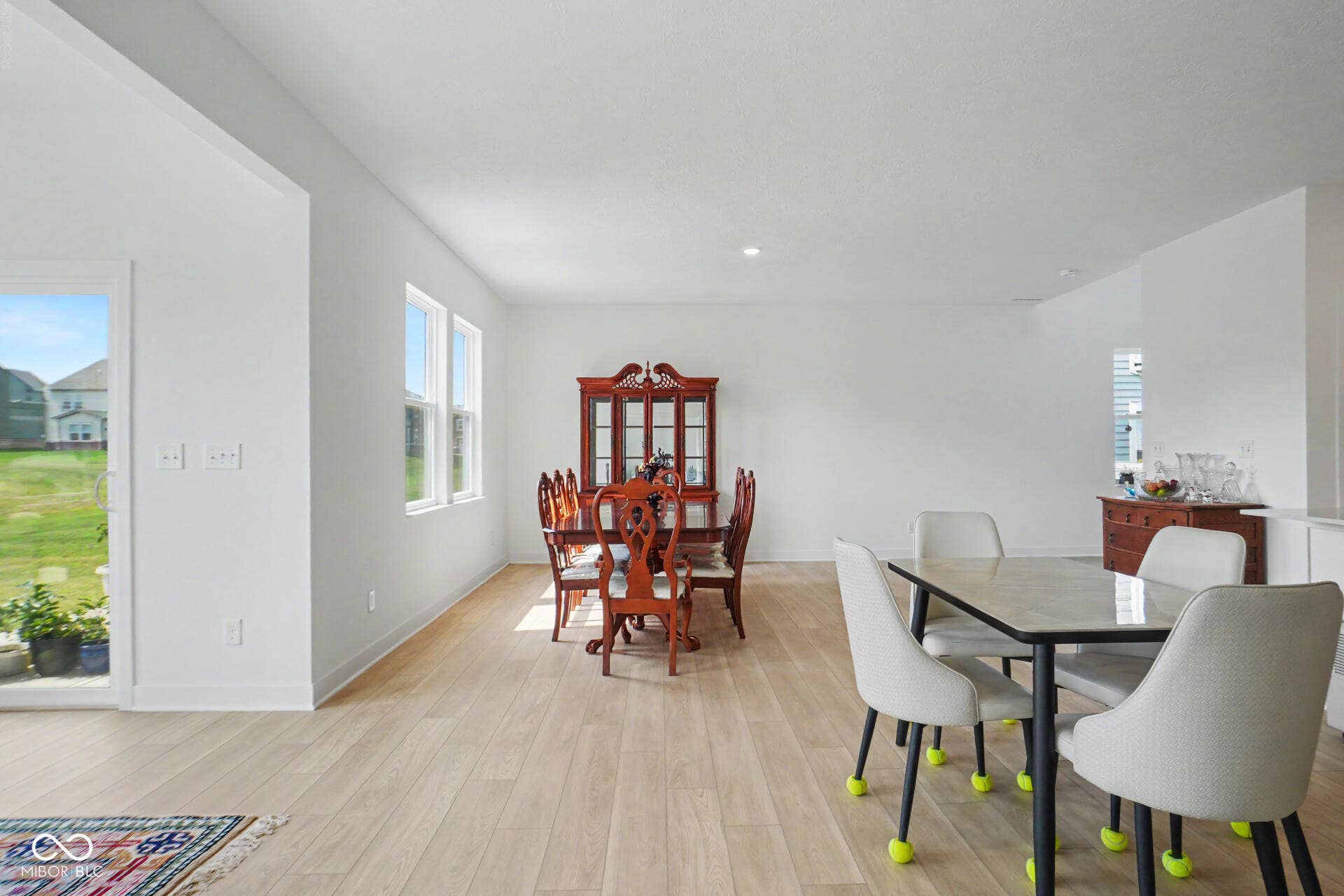 4357 Red Pine Drive, Bargersville, IN 46106 Expansive open-concept room with light wood-finish flooring, multiple windows, and a sliding glass door