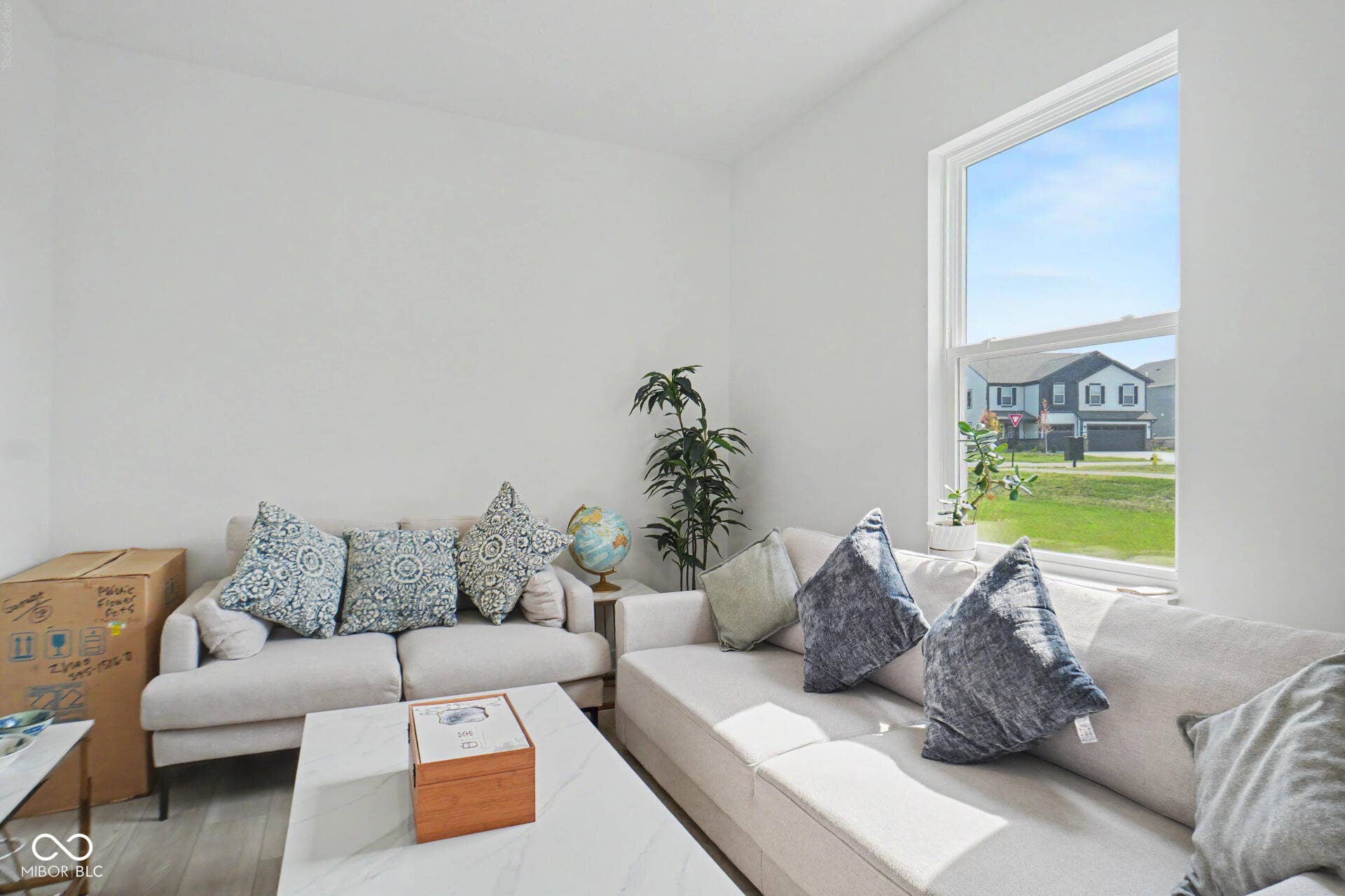 4357 Red Pine Drive, Bargersville, IN 46106 Bright, naturally lit living room featuring expansive windows with views of the surrounding landscape, light wood-finish flooring, and a neutral color palette with built-in seating arrangements
