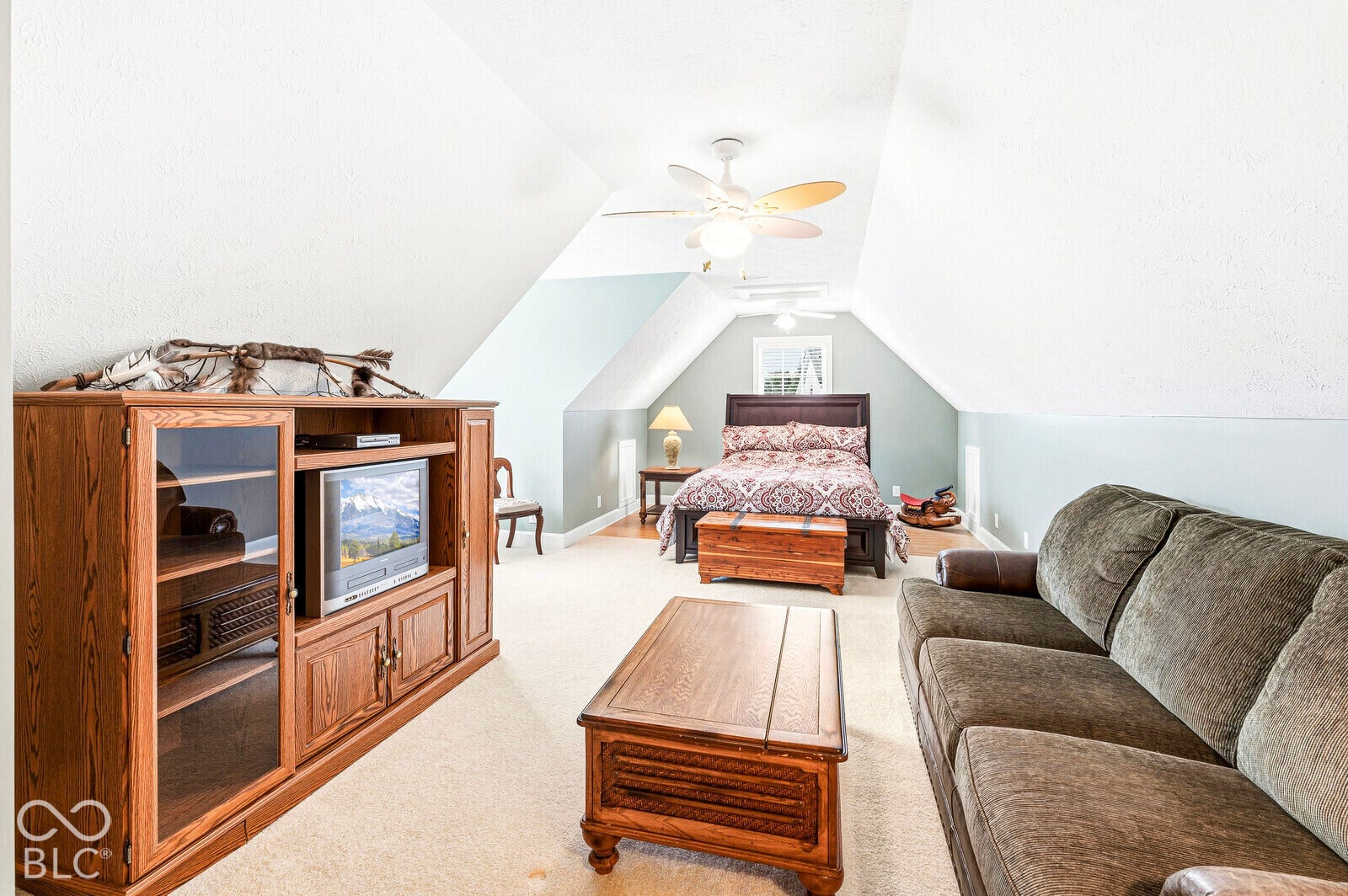 Carpeted flooring, vaulted ceilings, ceiling fan, and painted walls