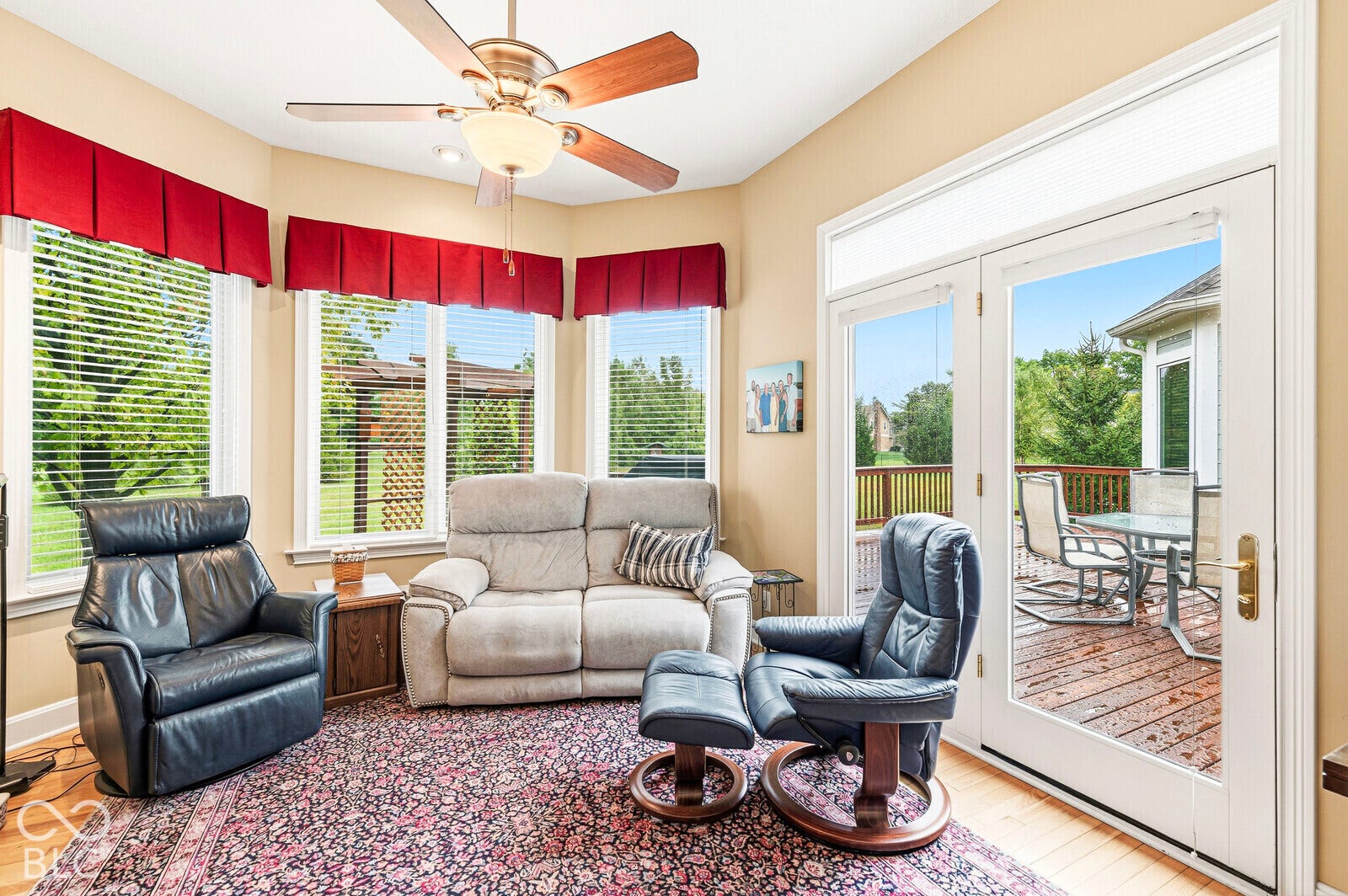 Bay window with multiple panes, ceiling fan, and double French doors opening to an exterior deck