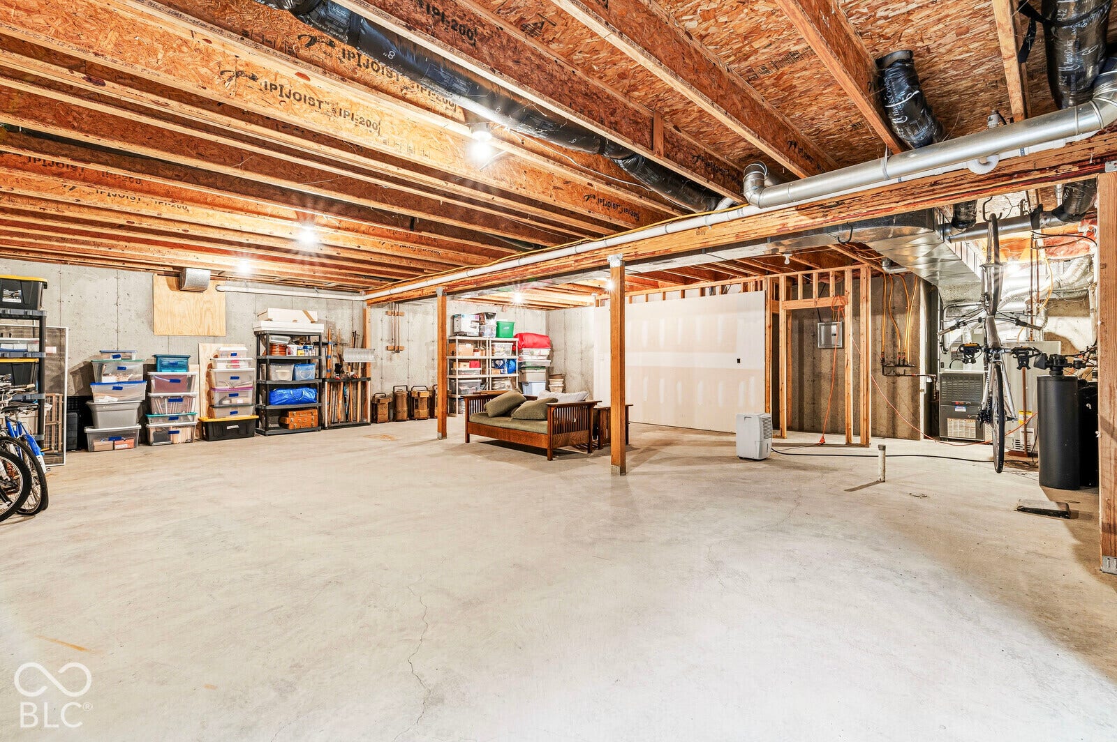 Unfinished basement with concrete flooring and exposed ceiling joists