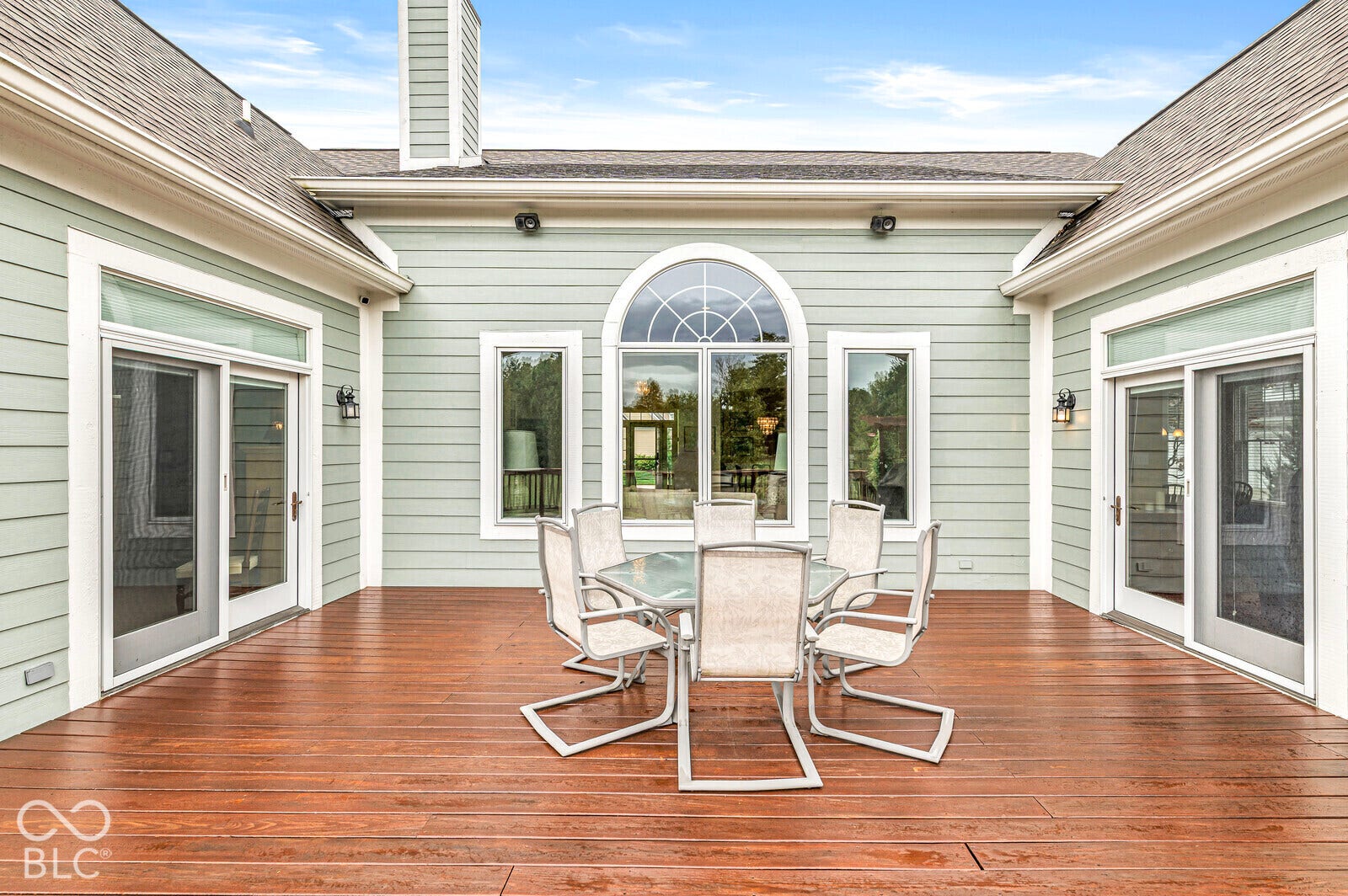 Expansive wood deck with light blue siding