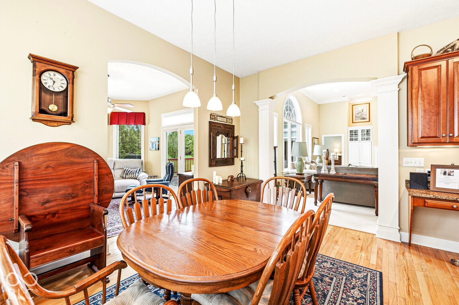 Arched entryways, wood-finish flooring, vaulted ceilings, pendant lighting, and built-in cabinetry