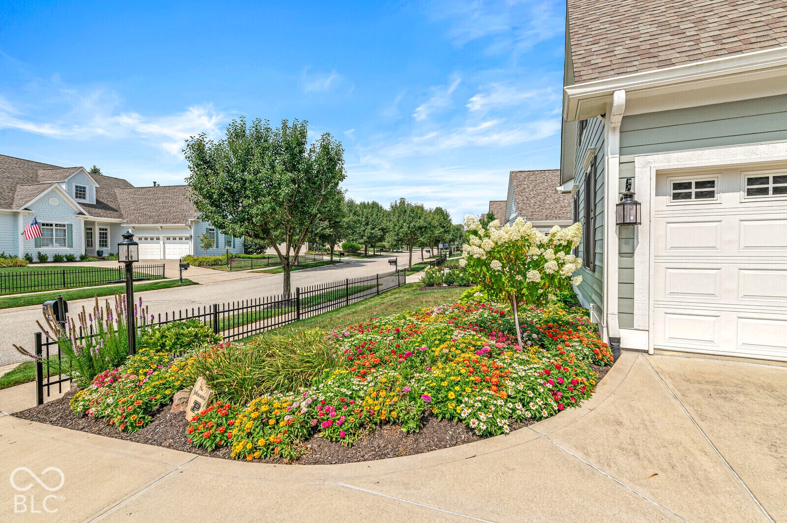 Landscaped garden bed with colorful plantings and a blooming shrub