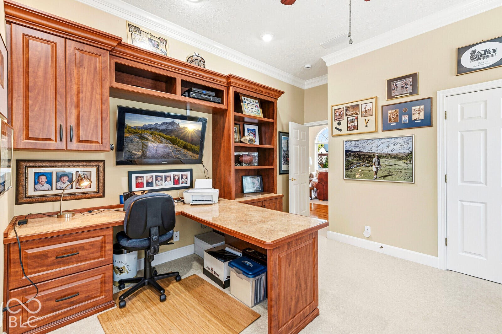 Custom built-in desk with wood-finish cabinetry, integrated shelving, and a neutral-toned countertop