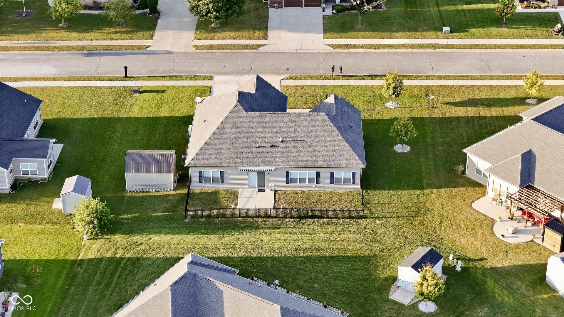 Spacious property featuring a fenced rear yard, two outdoor storage sheds, and a paved patio area