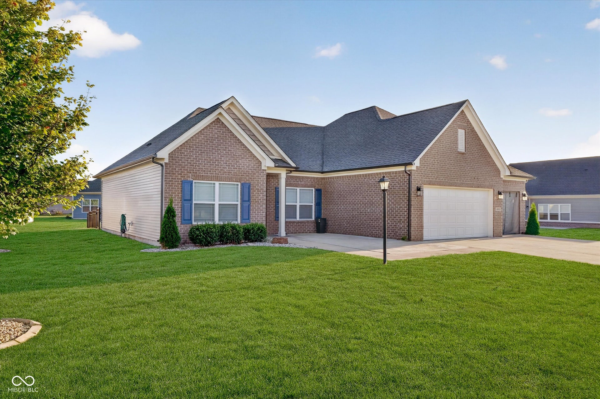 Brick exterior with white siding accents and a dark shingle roof