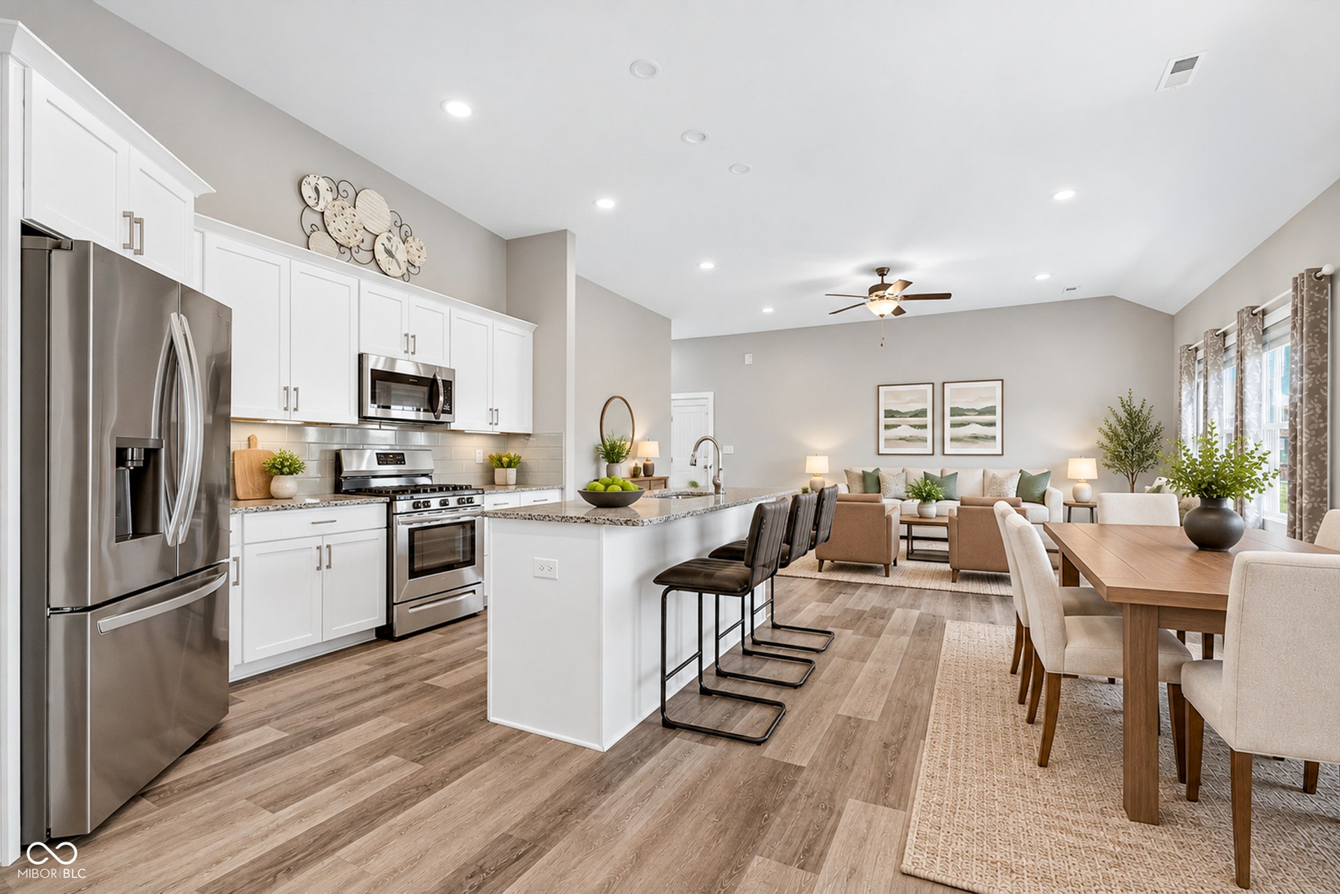 Virtually Altered - Modern kitchen with stainless steel appliances, white cabinetry, and a central island with a granite countertop