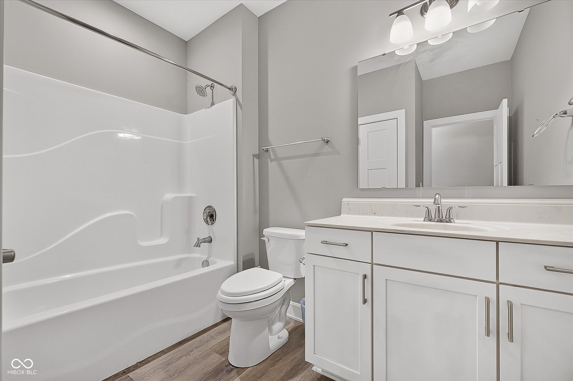 White vanity with chrome hardware, an integrated sink, and a framed mirror