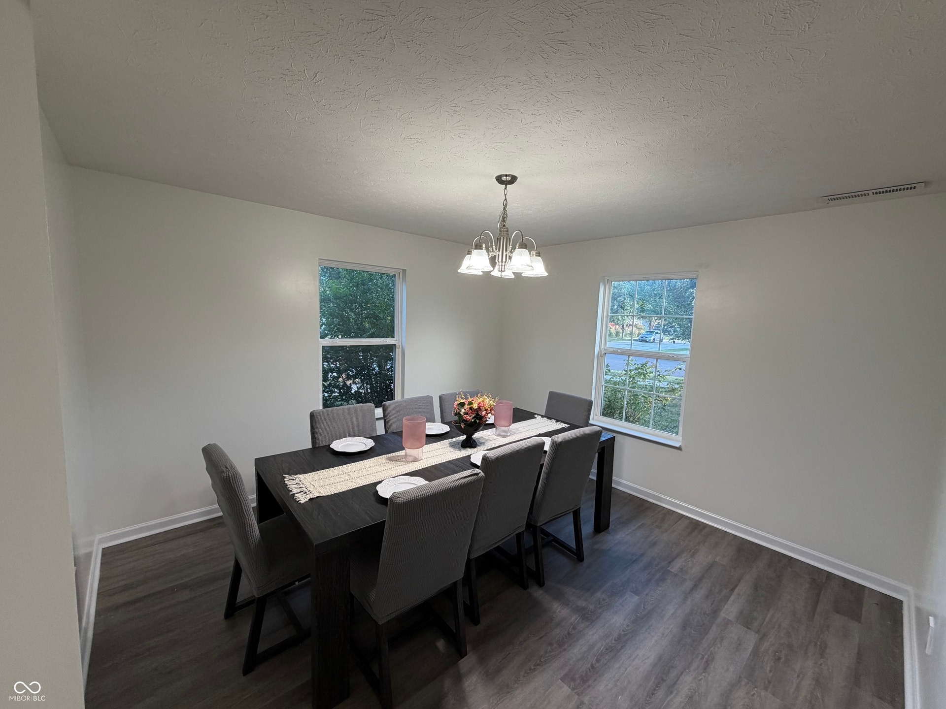 front room could be used as a flex room, office or dinning room. Recessed lighting, chandelier, light-toned walls, multiple windows, and wood-finish flooring