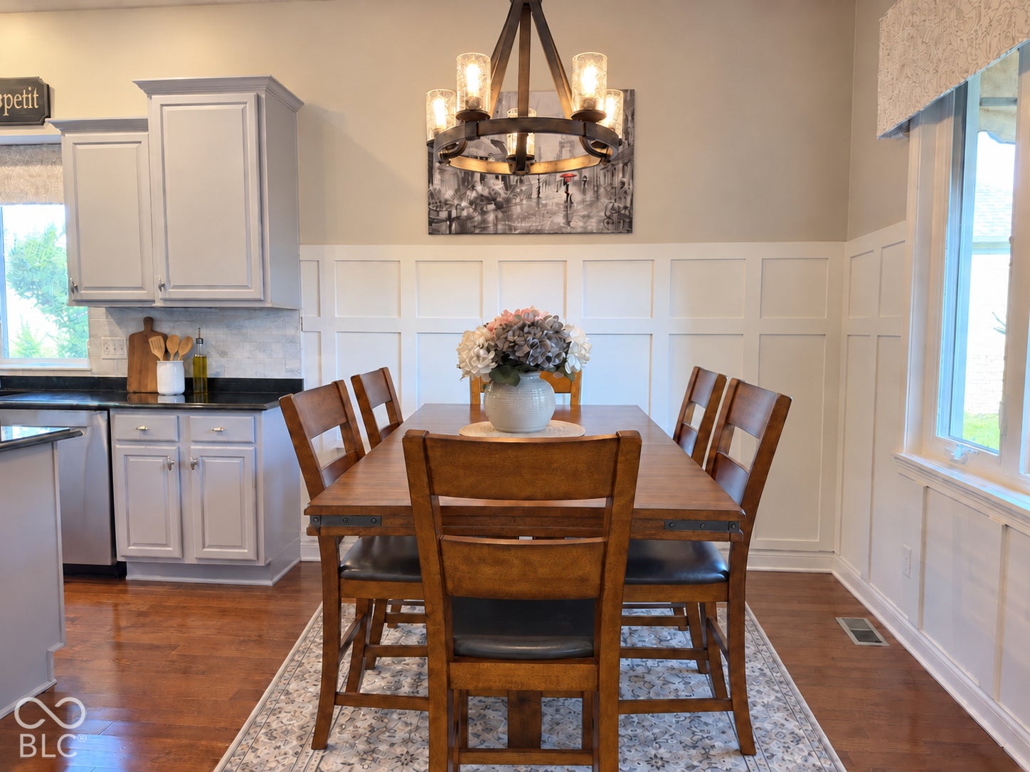 Engineered Hardwood flooring with white baseboards, neutral kitchen cabinetry, granite countertops, and full tile backsplash