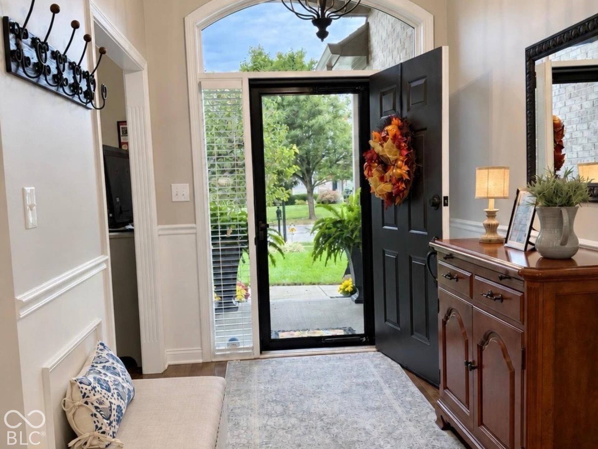 Arched transom window above a dark-paneled front door invite you to your new home. Newer storm door lets the light in and the elements out.