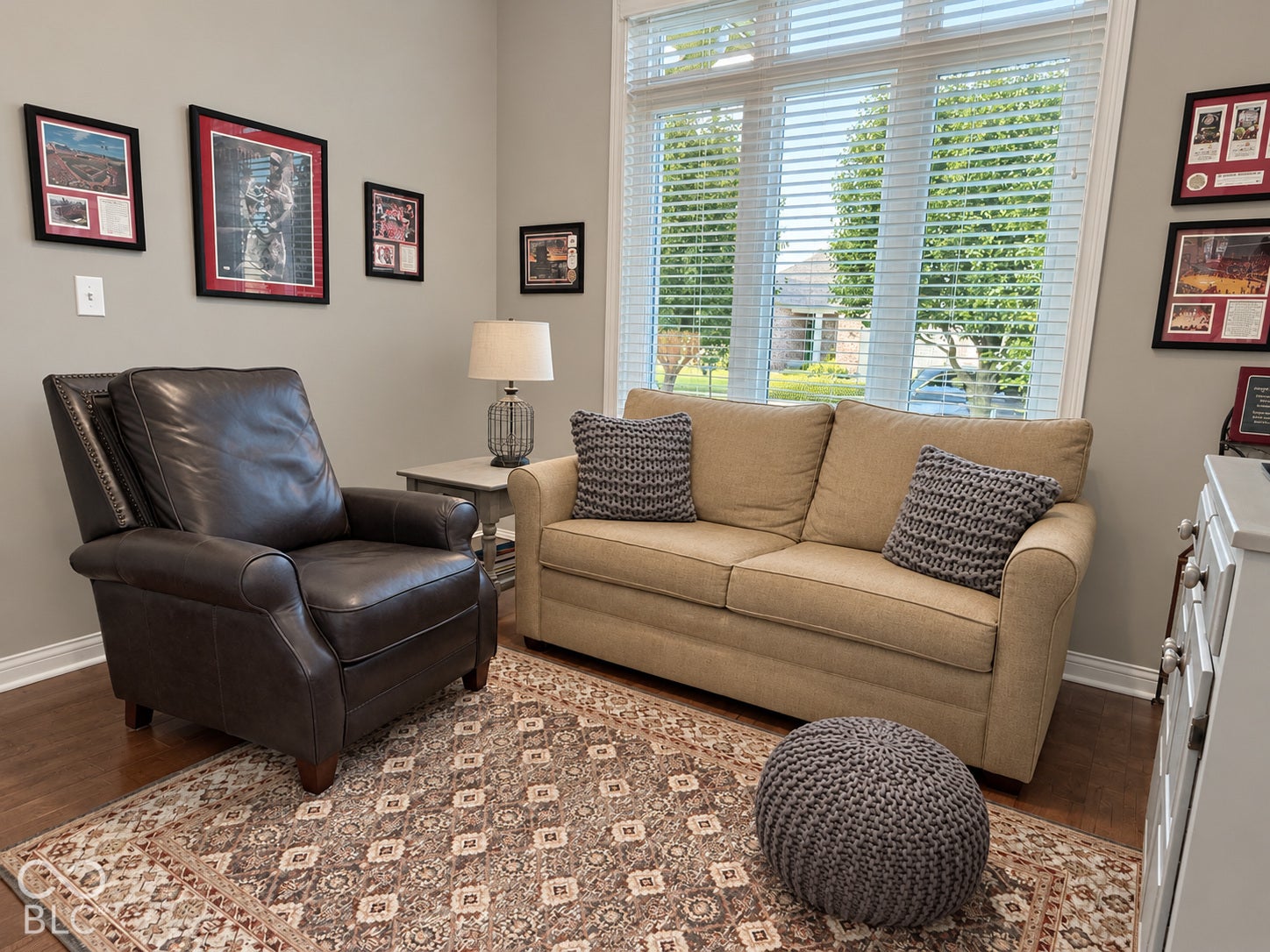 Wood-finish flooring with a multi-pane window, wall-mounted light switch, and painted walls