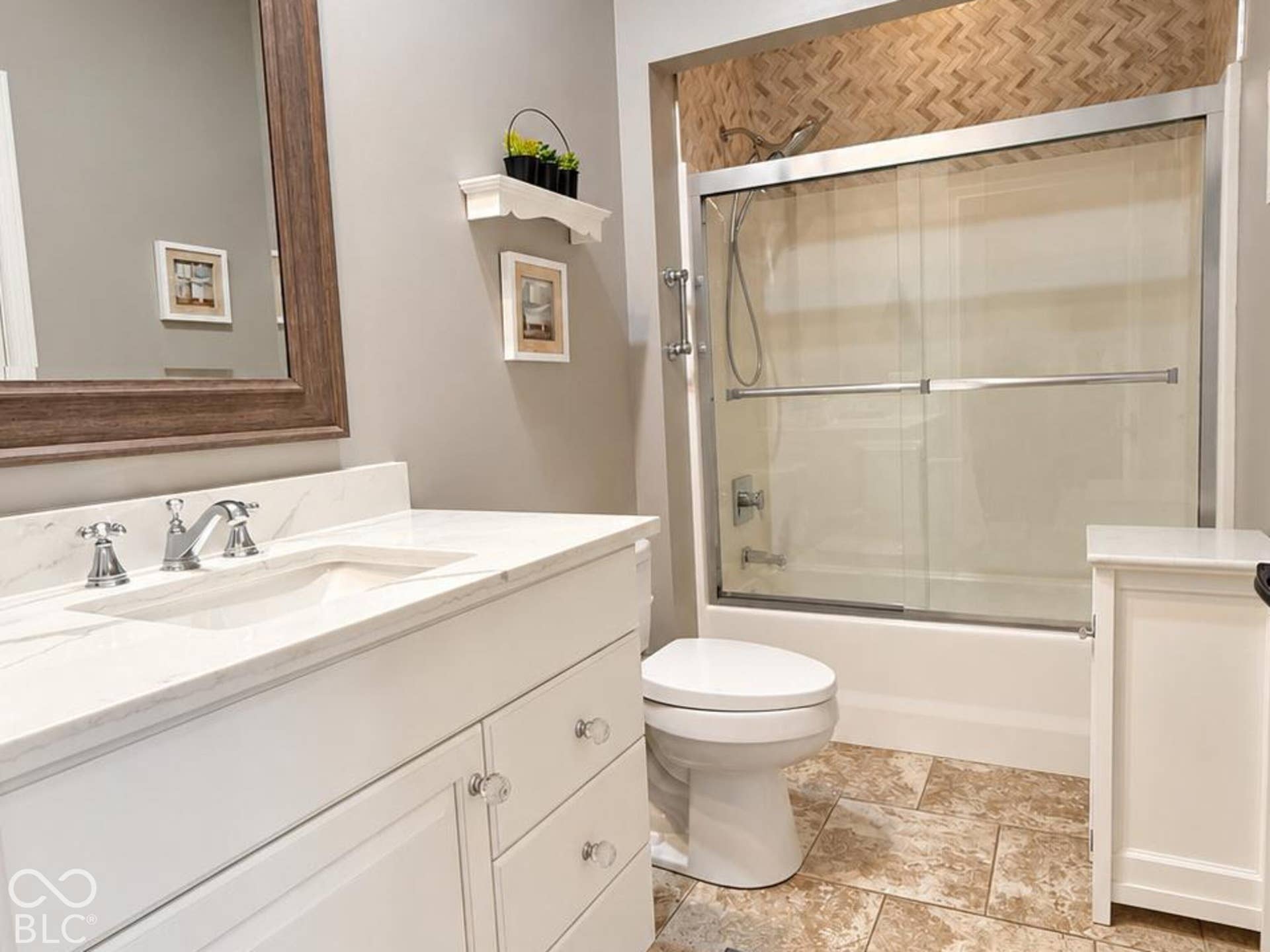 Virtually Altered - White vanity with neutral countertop and and linen closet, tiled floor.